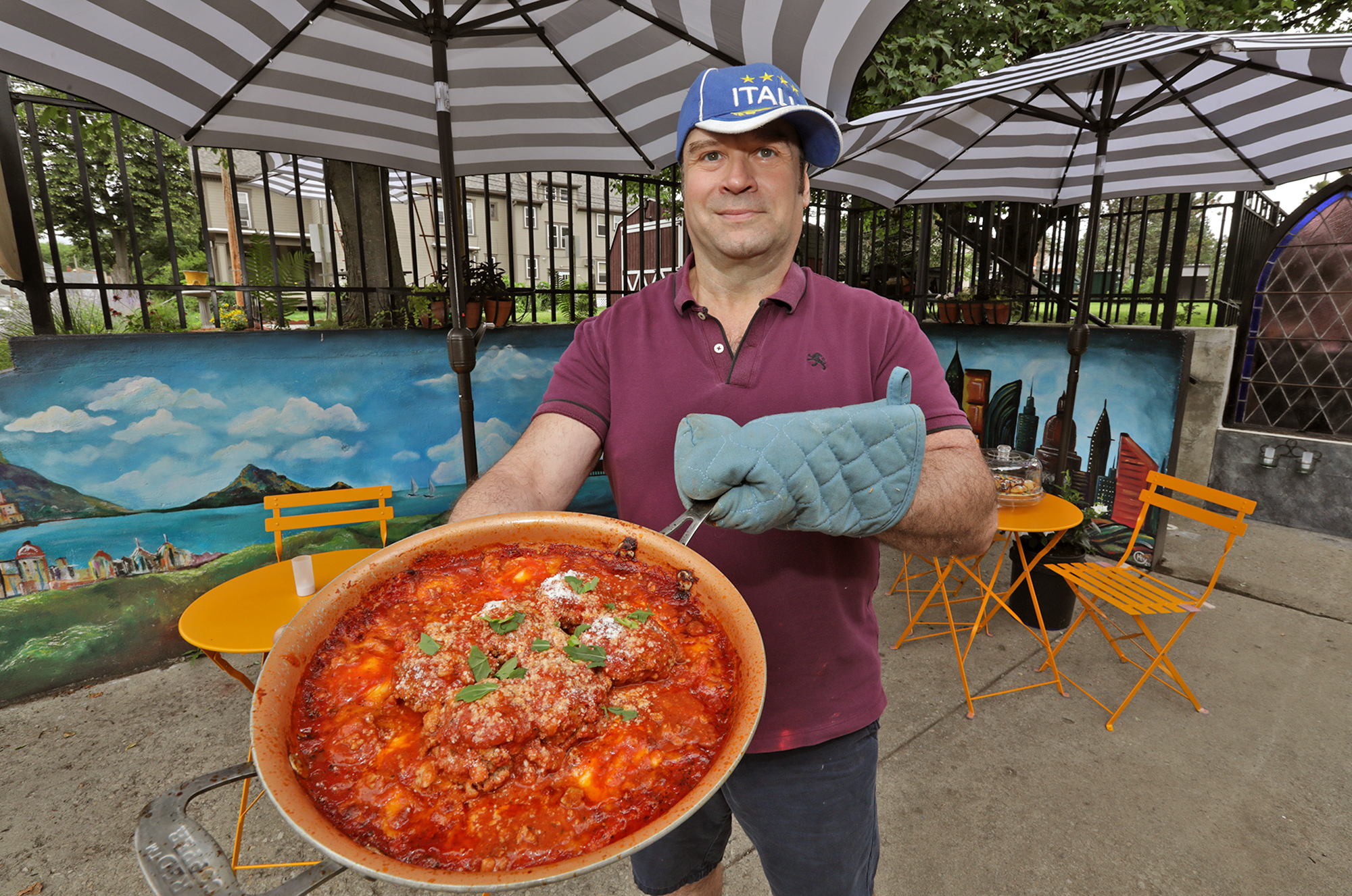 Tom Thompson, the owner and chef at Eatly American/Italian Comfort Cafe, with one of his ravioli and meatball dishes. BILL LACKEY/STAFF