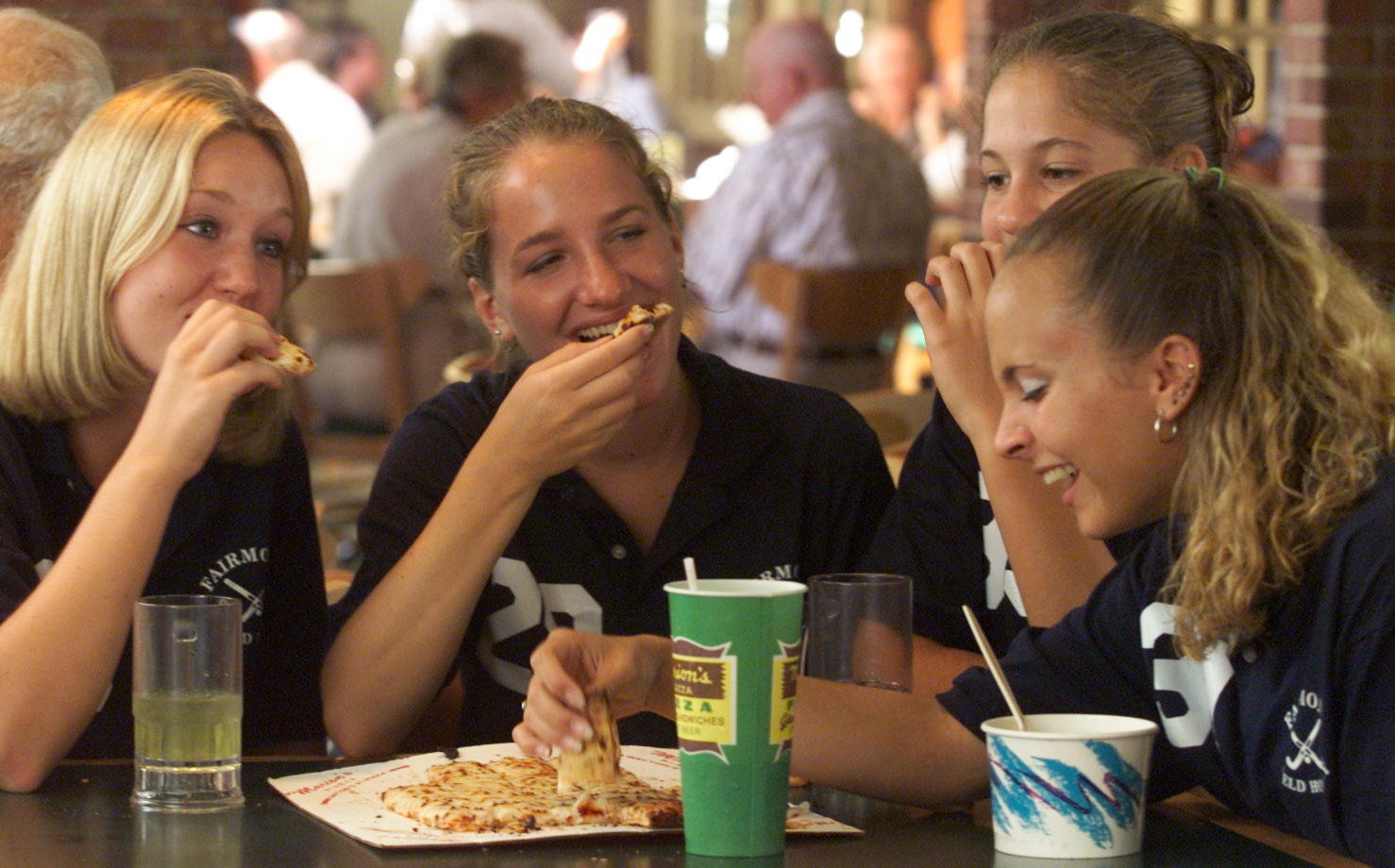 Ashley Peterson, Jamie Kremmel, Abby Pifer and Emily Campbell all members of the Fairmont High School Field Hockey team, enjoy some pizza after team pictures at the Marion's Piazza (cq)location at the Town and Country Shopping Center. They waited for about 1/2 hour in line before being served. Marion's celebrated their 35 anniversary by rolling back their menu to 1965 prices. Needless to say it was a huge success. Store manager, Jim Randall figured they would serve 2000 large pizzas in the 12 hour span of the special event.