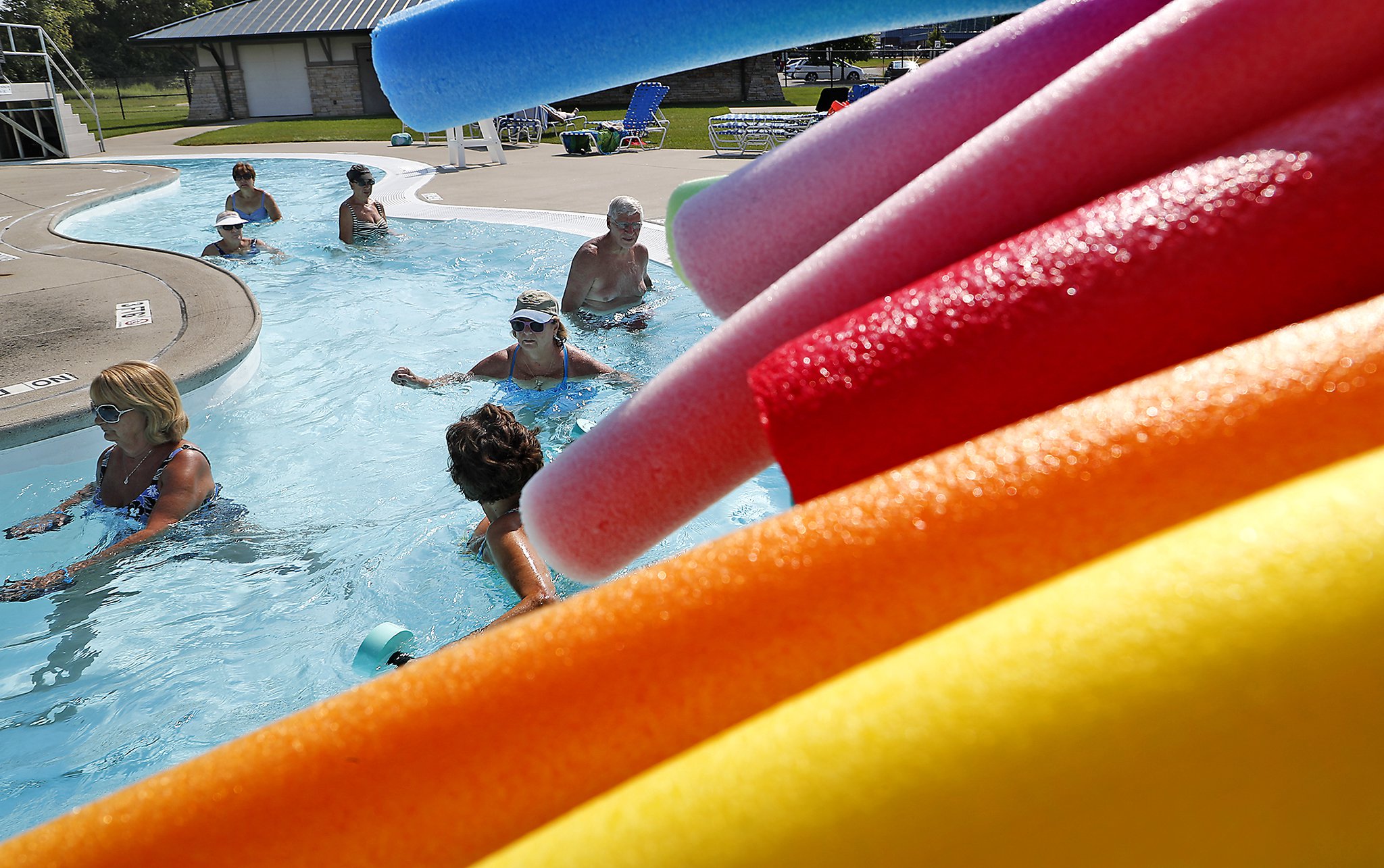 A group walks past a pile of pool noodles in the Lazy River at Splash Zone. The flowing water pushes the walkers along allowing them to exercise without putting stress on the joints. Bill Lackey/Staff