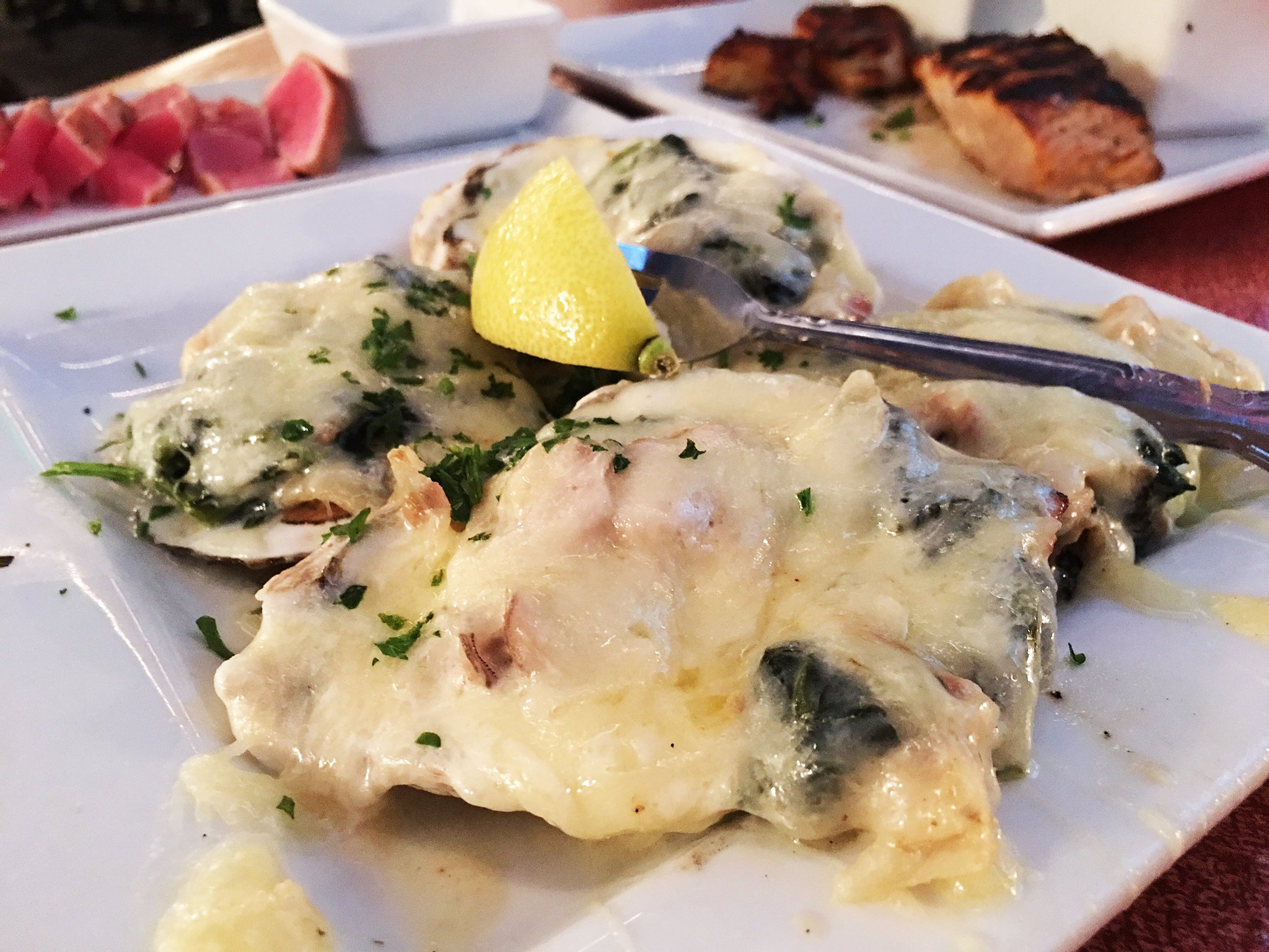 The classic oysters Rockefeller ($12) in the foreground is one of the highlights of the Sweeney’s menu as well as the large Chesapeake Bay oysters served on the half shell over ice ($2.50 each). The seared ahi tuna ($13) and Captain s Seafood Platter ($23) can be seen in the background. ALEXIS LARSEN/CONTRIBUTED