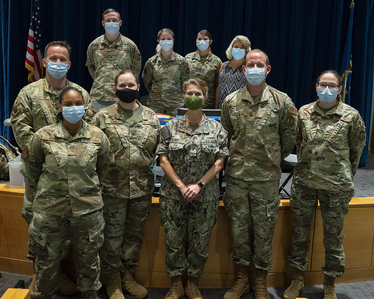 Rear Adm. Kristen Fabry (center), Defense Logistics Agency Land and Maritime commander, poses Oct. 1 with a group of 88th Medical Group Airmen during a visit to Wright-Patterson Medical Center. The Airmen were part of a team that traveled to Columbus earlier this year to administer COVID-19 vaccines to DLA members in Fabry’s command, and she wanted to personally thank them. U.S. AIR FORCE PHOTO/R.J. ORIEZ