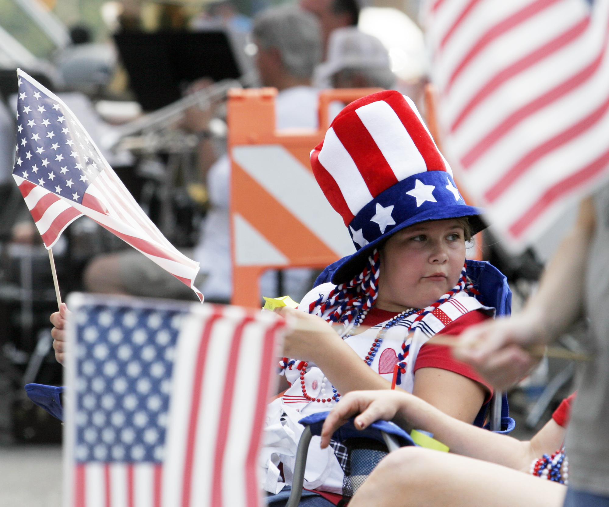 Parade watchers wave flags and dress in patriotic attire during the annual Fairborn Fourth of July parade. STAFF FILE PHOTO