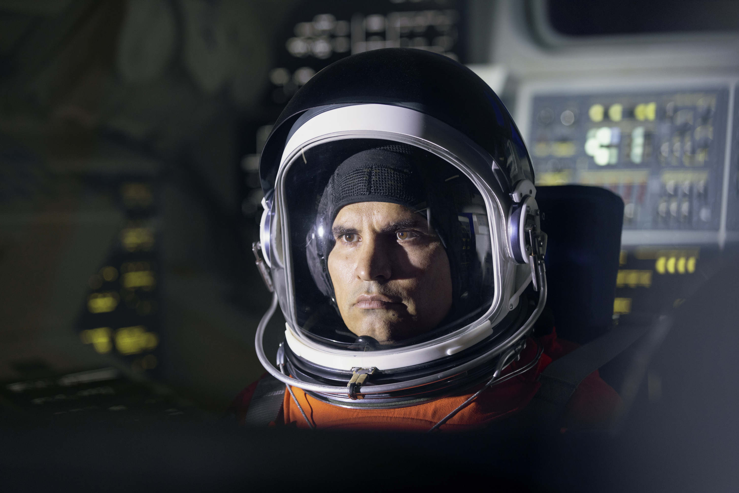 Un niño con un casco de astronauta y mirando hacia arriba.