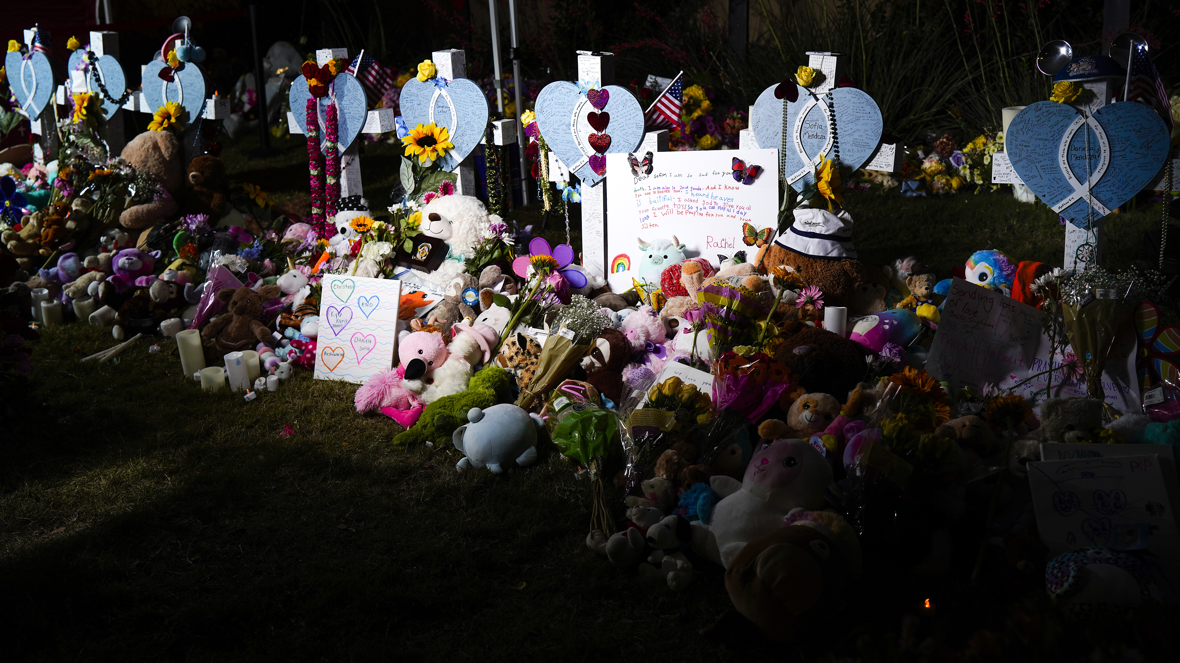 Flowers, toys and messages surrounded a row of eight crosses near an entrance to the Allen...