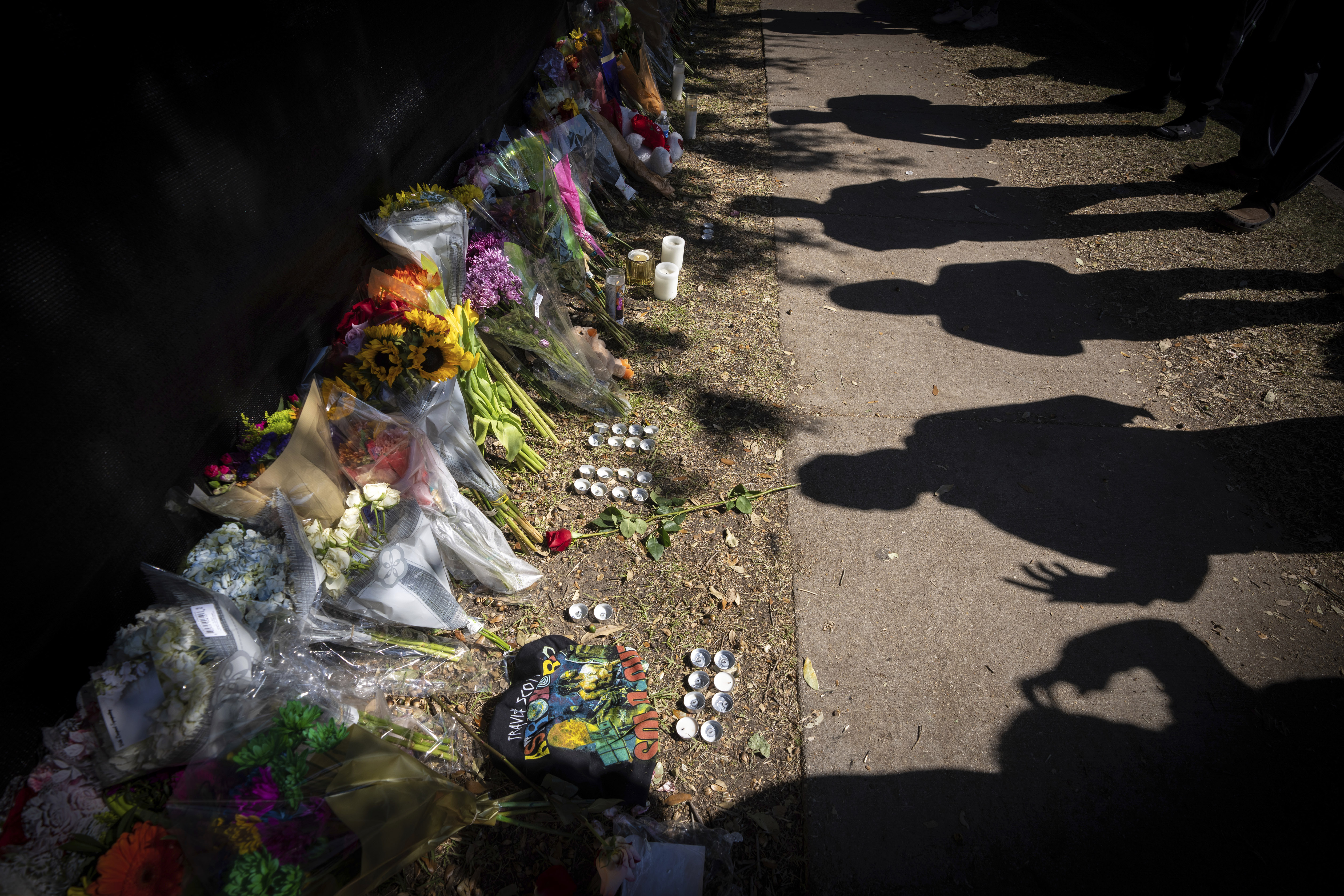 Visitors cast shadows at a memorial to the victims of the Astroworld concert in Houston on...