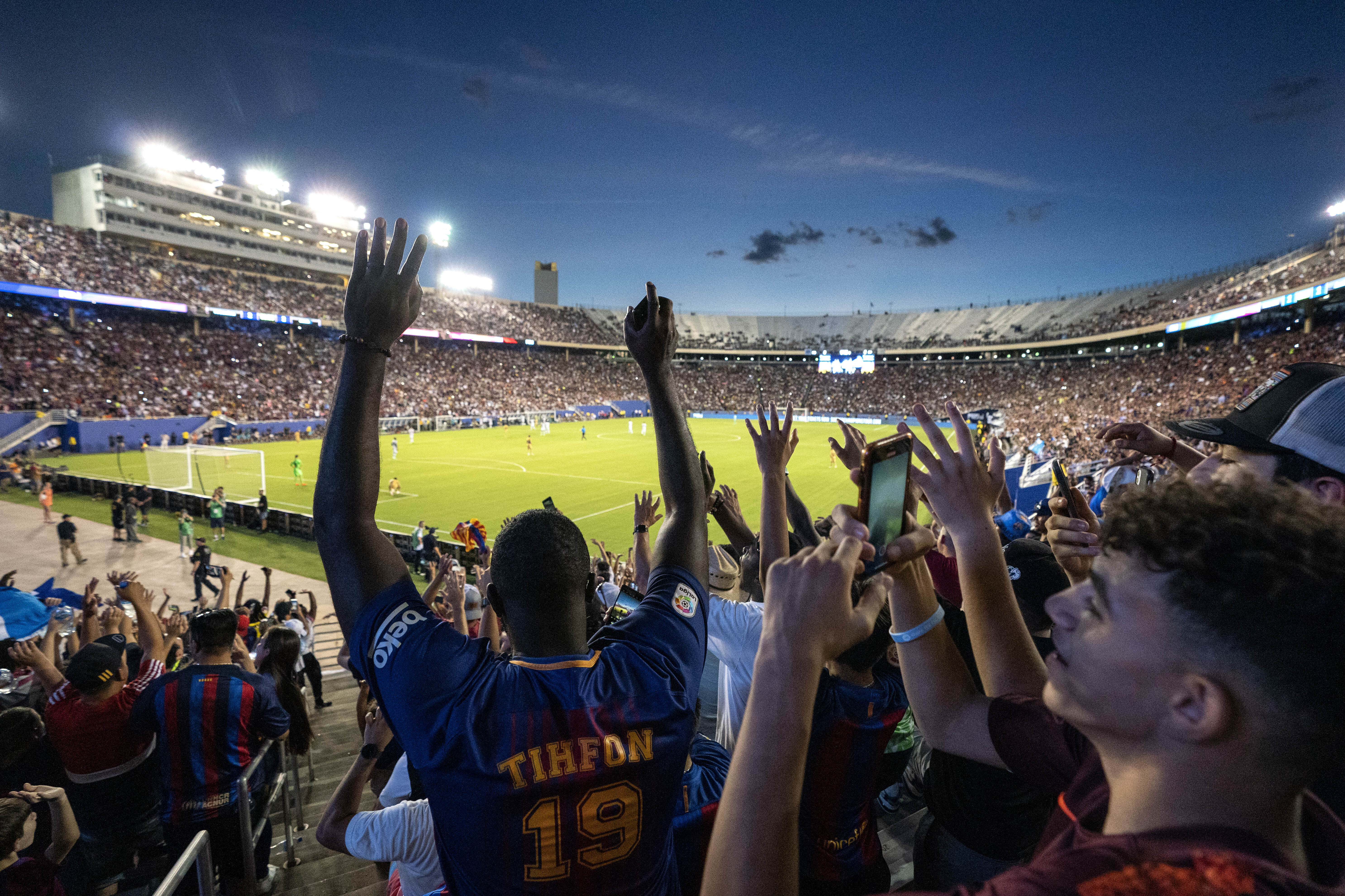 A crowd of over 58,000 fans does the wave during the second half of a soccer match between...