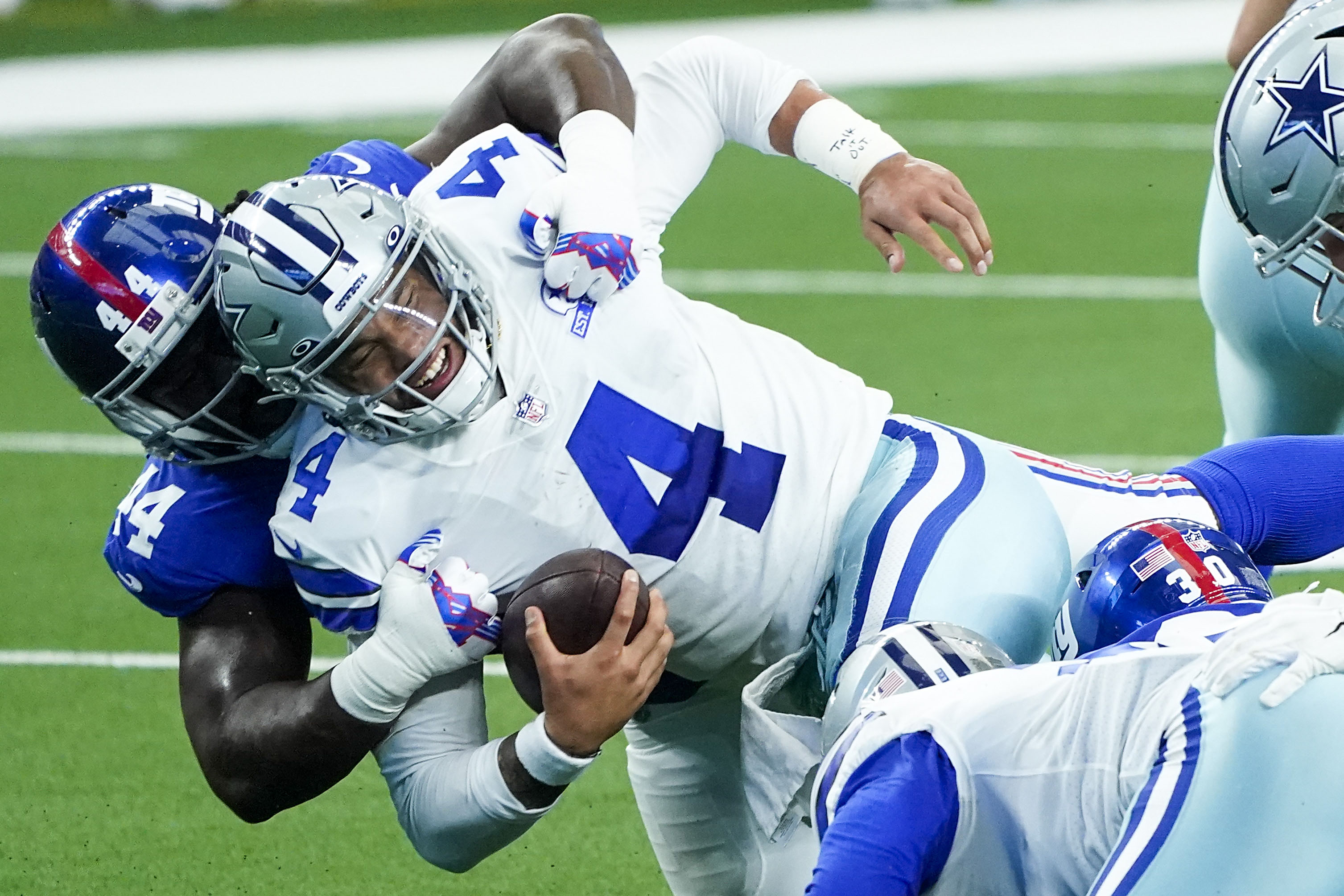 Jayron Kearse of the Dallas Cowboys tackles Trevor Lawrence of the