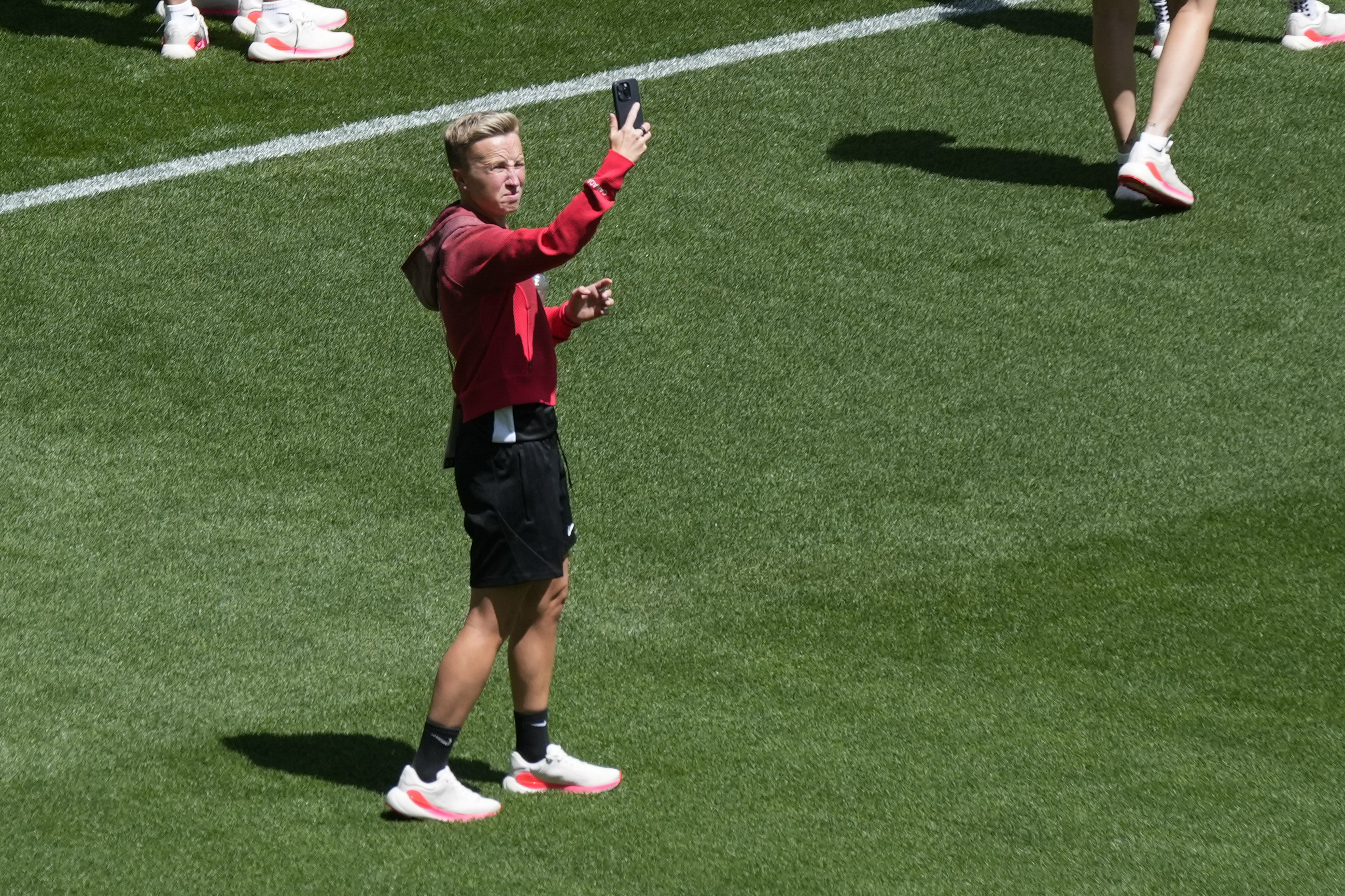 Coach Beverly Priestman of Canada takes photos on the pitch at Geoffroy-Guichard Stadium...