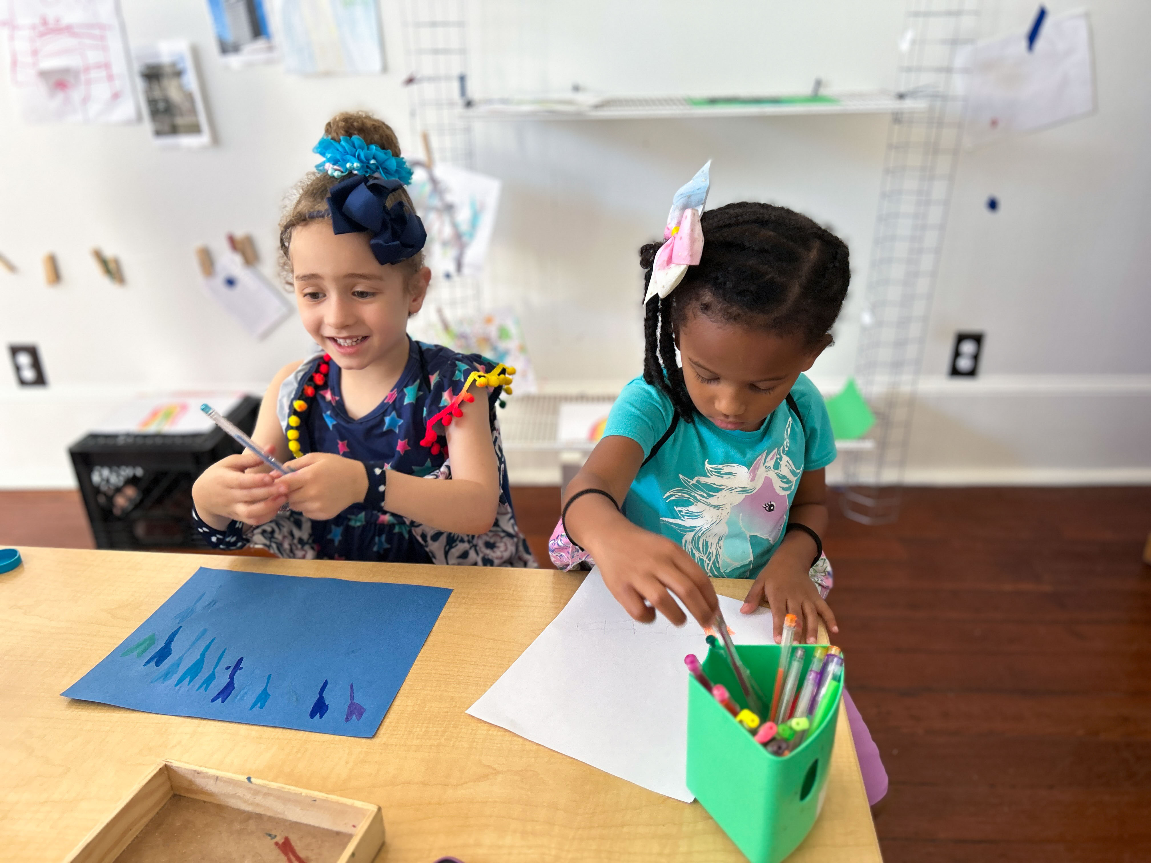 Two girls draw during an activity at Early Partners, a child care center in New Orleans....