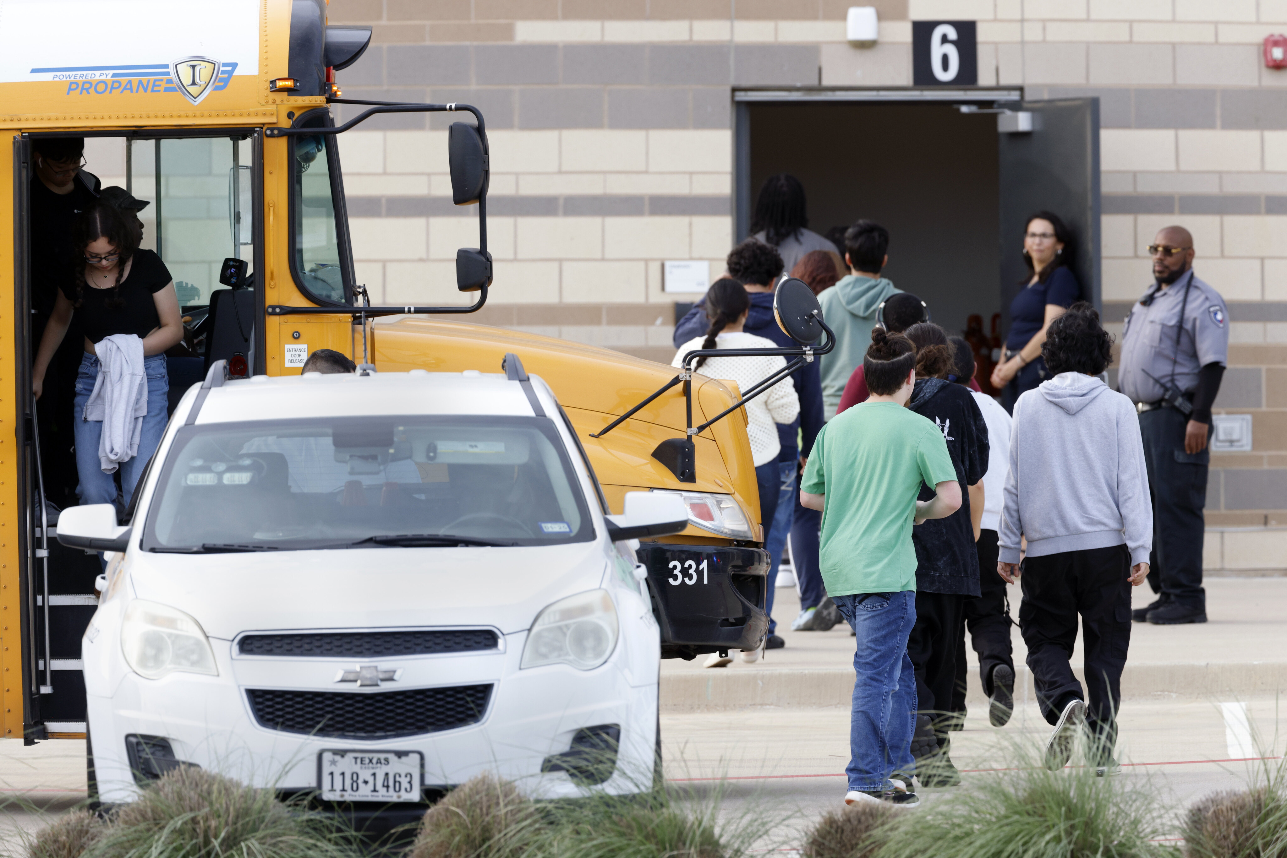 Students from Bowie High School exit a bus and enter the reunification center at Arlington...