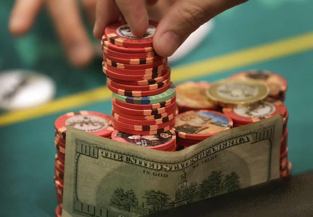 A poker player takes his ante from his stack of chips during a game of Texas Hold 'Em.