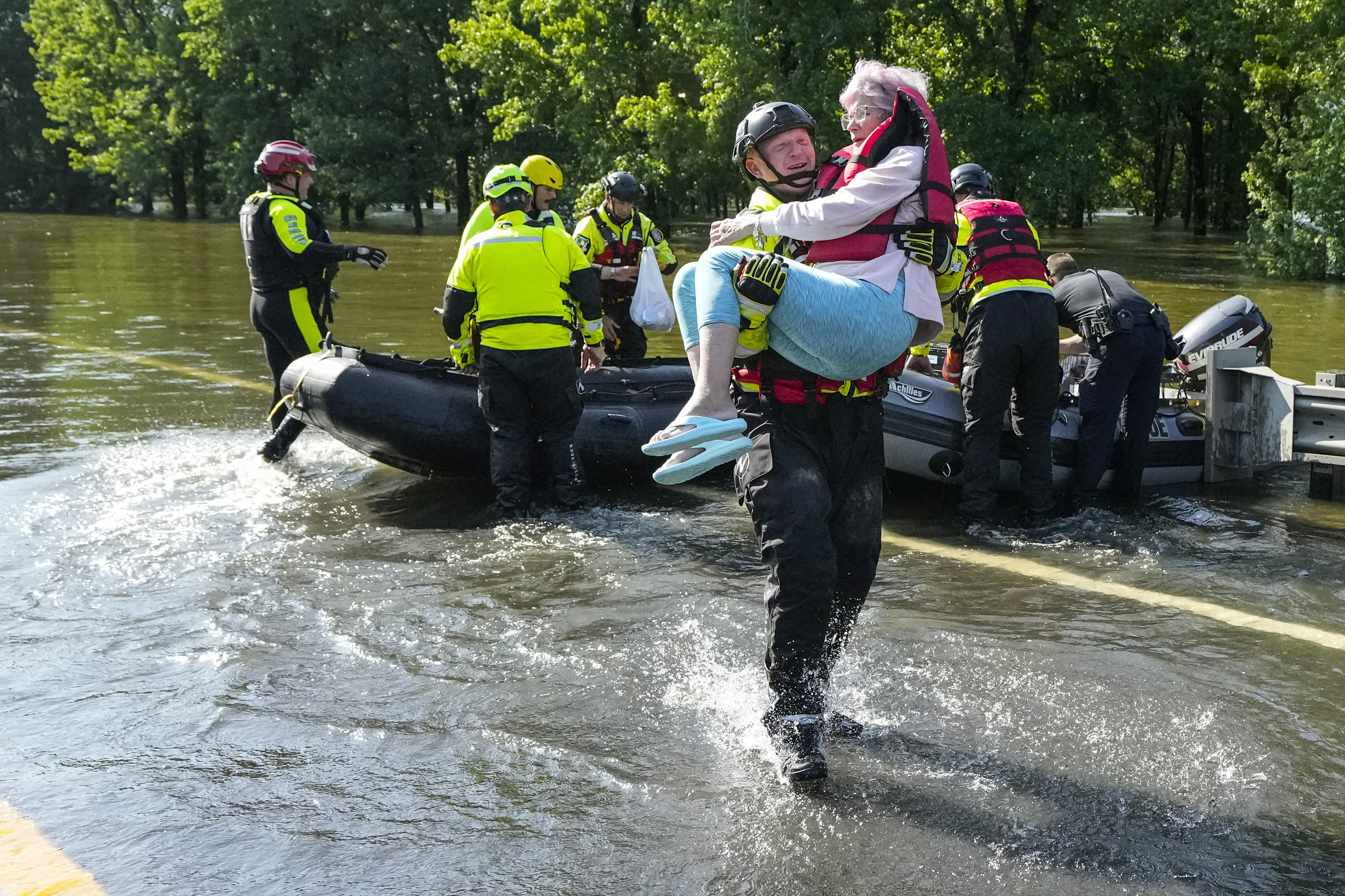 Conroe firefighter Cody Leroy carries a resident evacuated in a boat by the CFD Rapid...