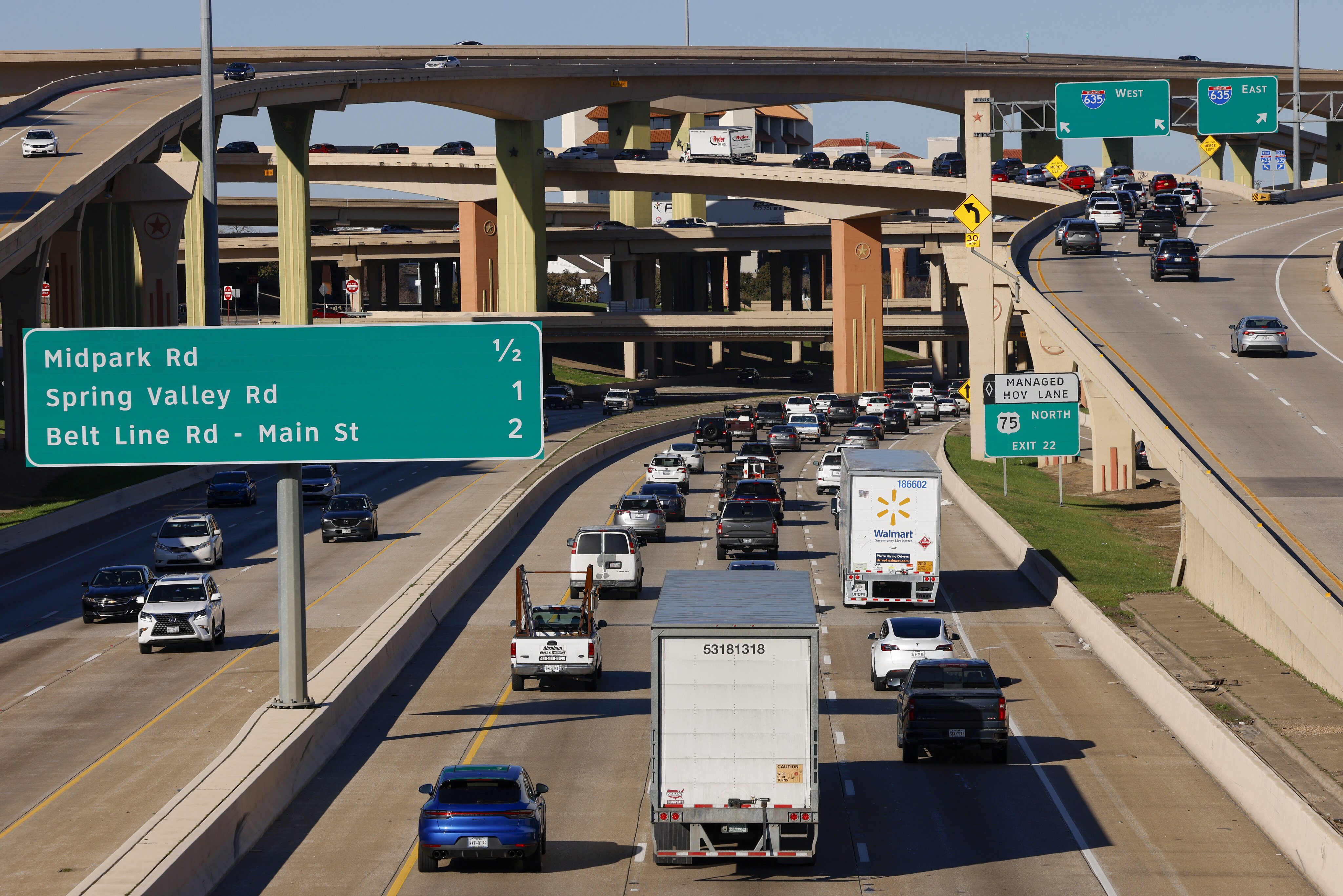 Several semi-trucks drive along U.S. 75 near the exit for Interstate 635 at the High Five...