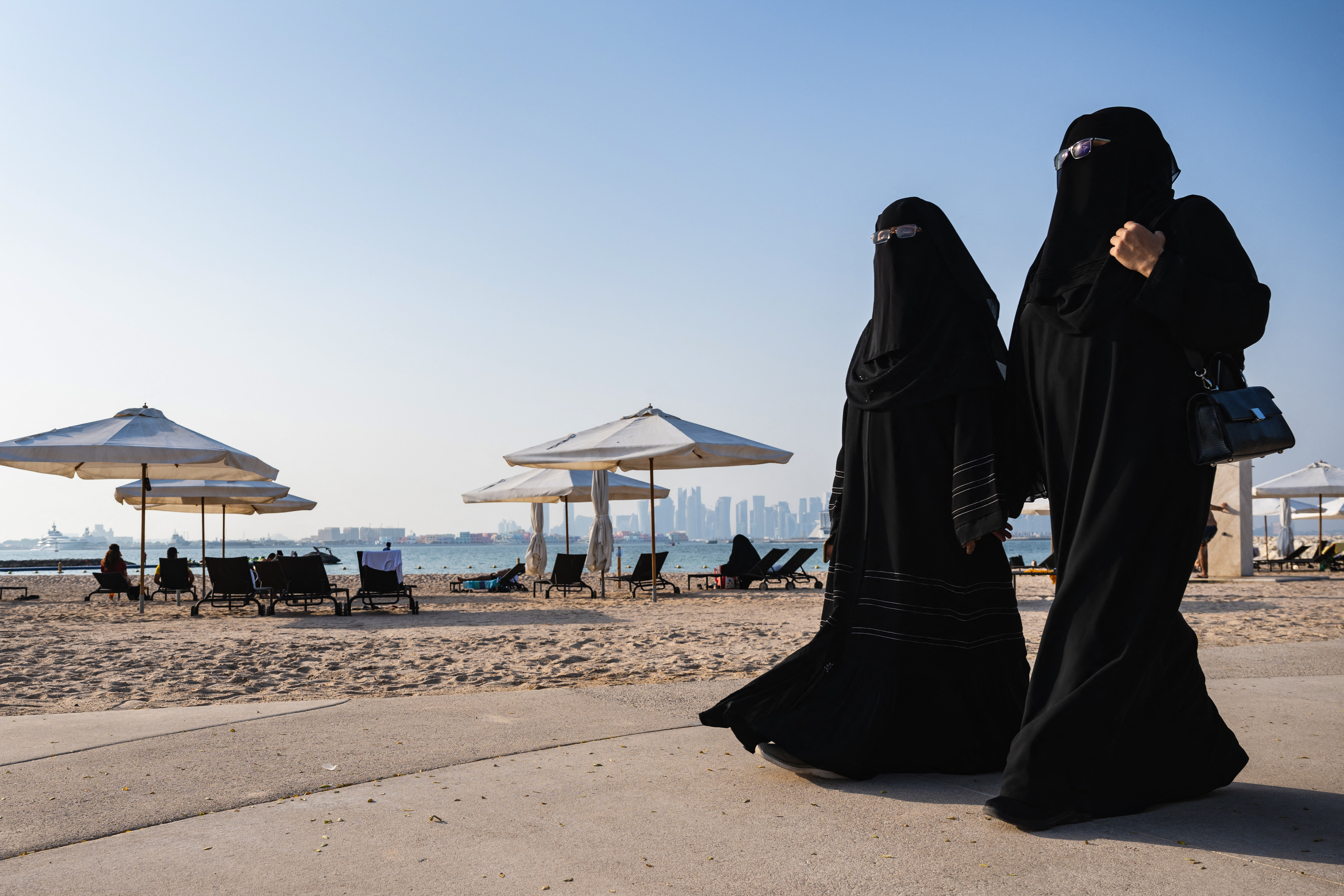 Las mujeres caminan en una playa cerca del Estadio 974 en Doha el 13 de noviembre de 2022, antes del torneo de fútbol de la Copa Mundial de Qatar 2022. (Foto de Andrej ISAKOVIC / AFP)