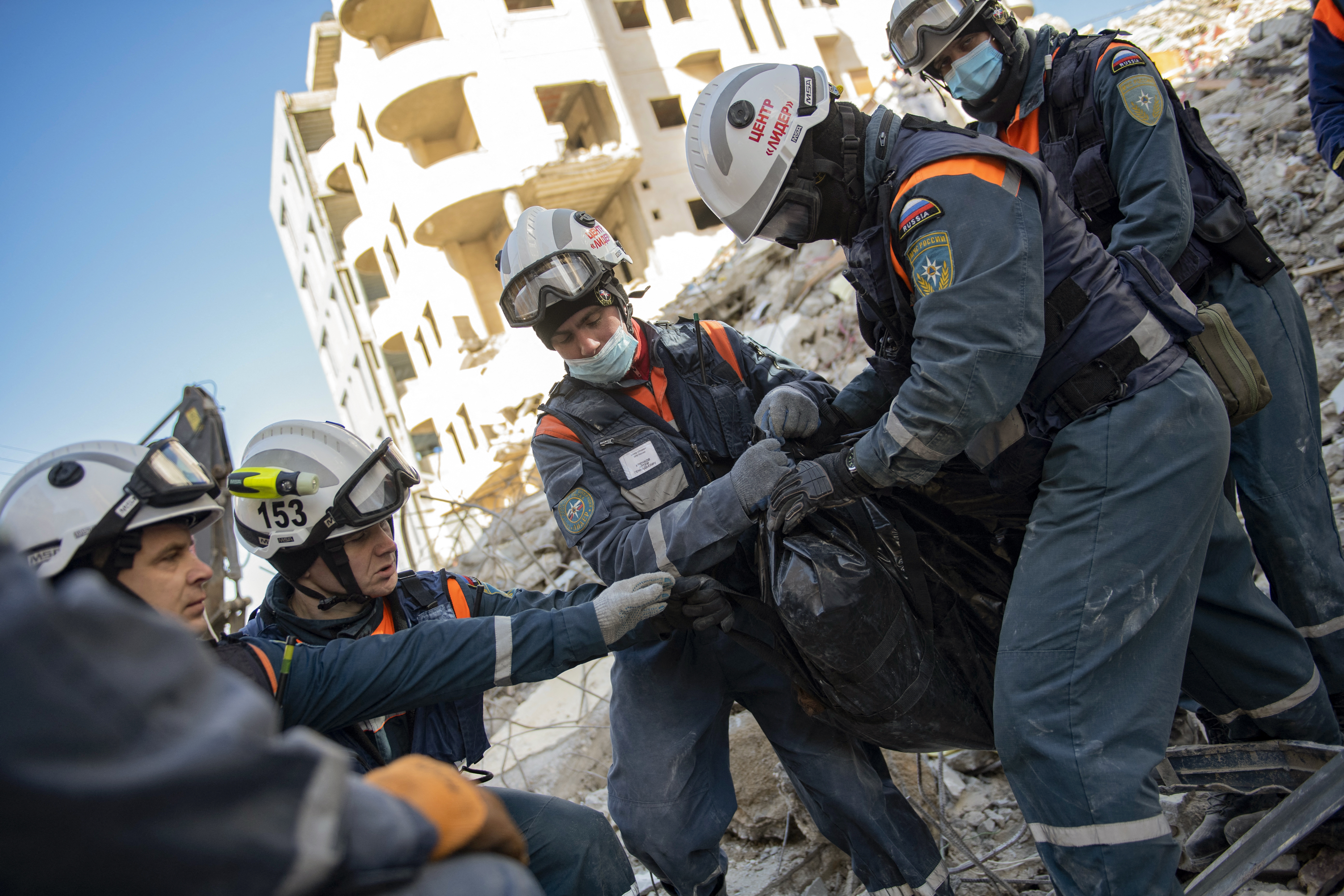 Rescatistas rusos recuperan un cuerpo de entre los escombros de un edificio derrumbado en la ciudad de Jableh, controlada por el régimen de Siria, en la provincia de Latakia, al noroeste de la capital Damsco, el 8 de febrero de 2023. (Foto: AFP).