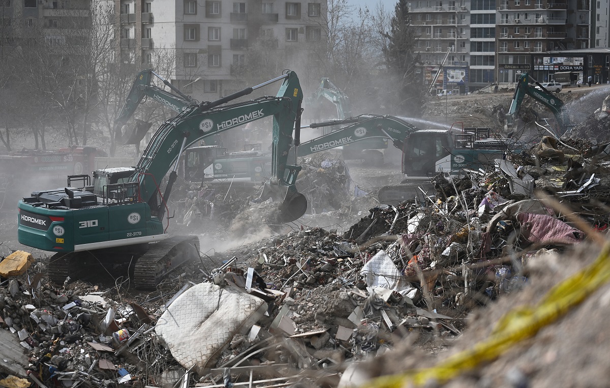 Los trabajadores operan maquinaria pesada mientras limpian los escombros del edificio Ebrar derrumbado en Kahramanmaras, el 4 de marzo de 2023, un mes después de que un terremoto masivo azotara el sureste de Turquía. (Foto de Eylul YASAR / AFP)