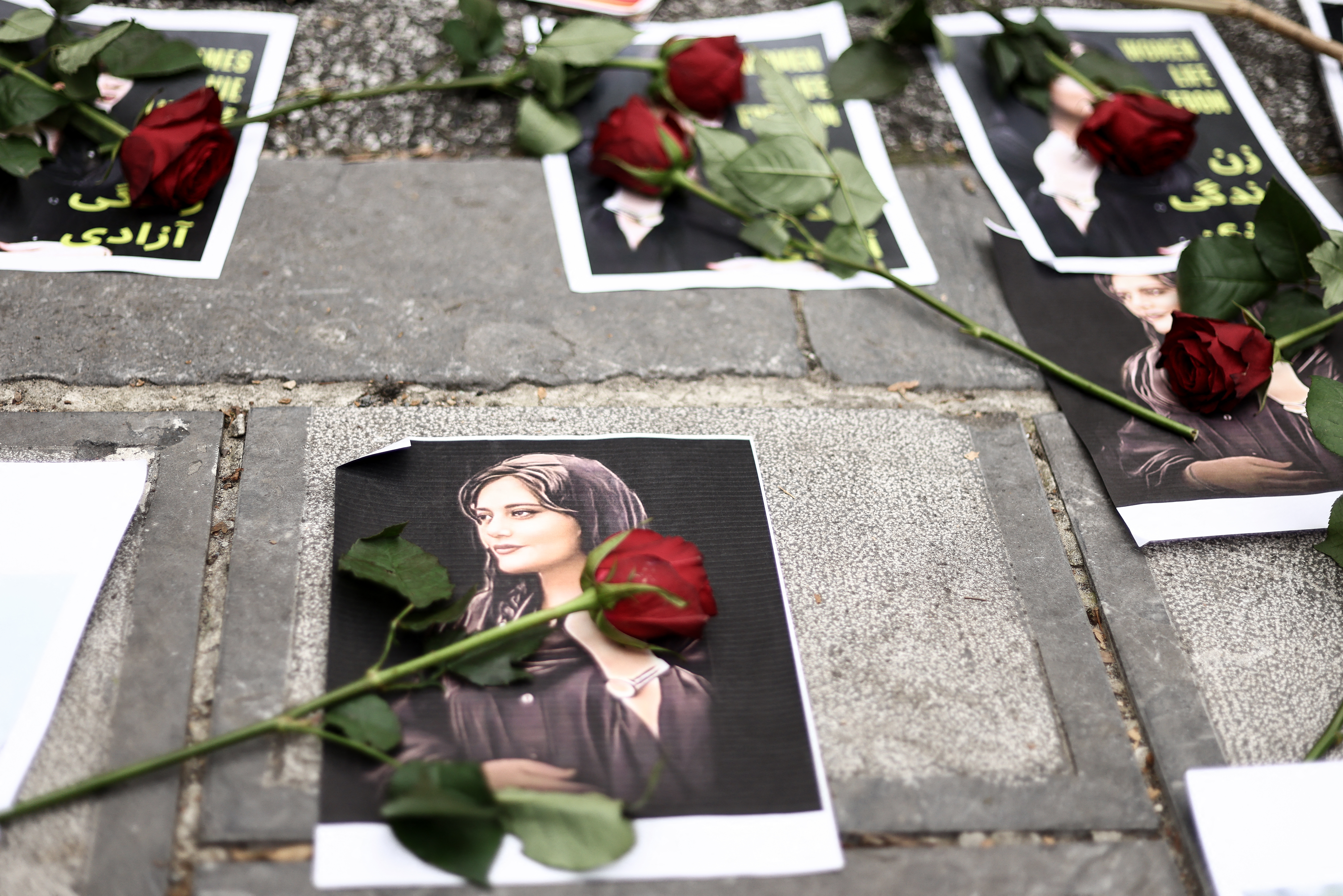 Se ven flores en un retrato de Mahsa Amini durante una manifestación en su apoyo frente a la embajada iraní en Bruselas, el 23 de septiembre de 2022, luego de la muerte de una mujer iraní luego de su arresto por parte de la policía moral del país en Teherán. (Foto por Kenzo TRIBOUILLARD / AFP)