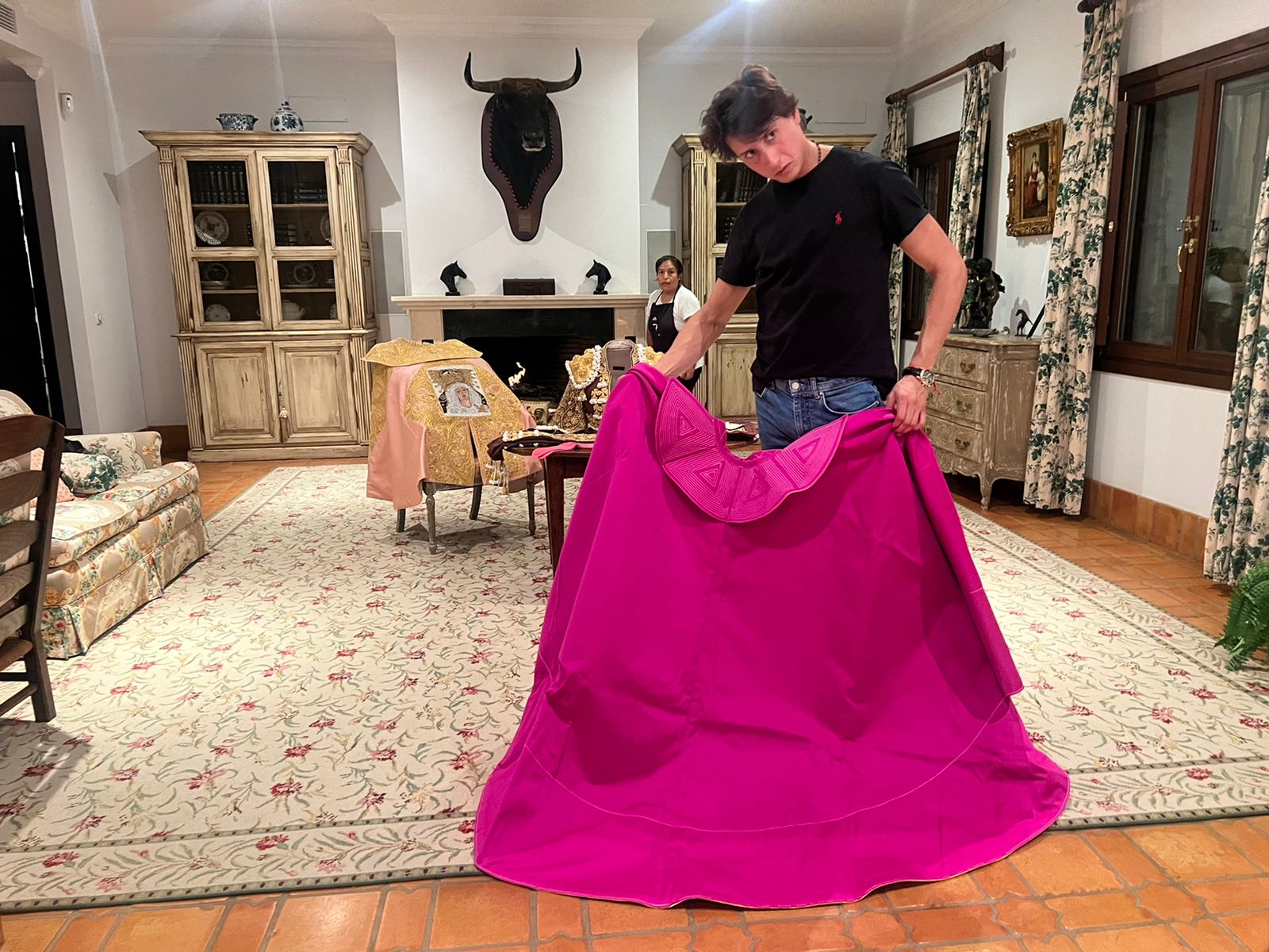 toreando de salón en su finca en las afueras de Sevilla. Detrás suyo la señora Melita, de Junín, que trabaja con el. En la pared, la cabeza del toro Buzonero al que le cortó dos orejas en Madrid, 2016, el día de su confirmación. Con ese toro empezó todo lo que sucede ahora. (Fotos: Jaime Bedoya)