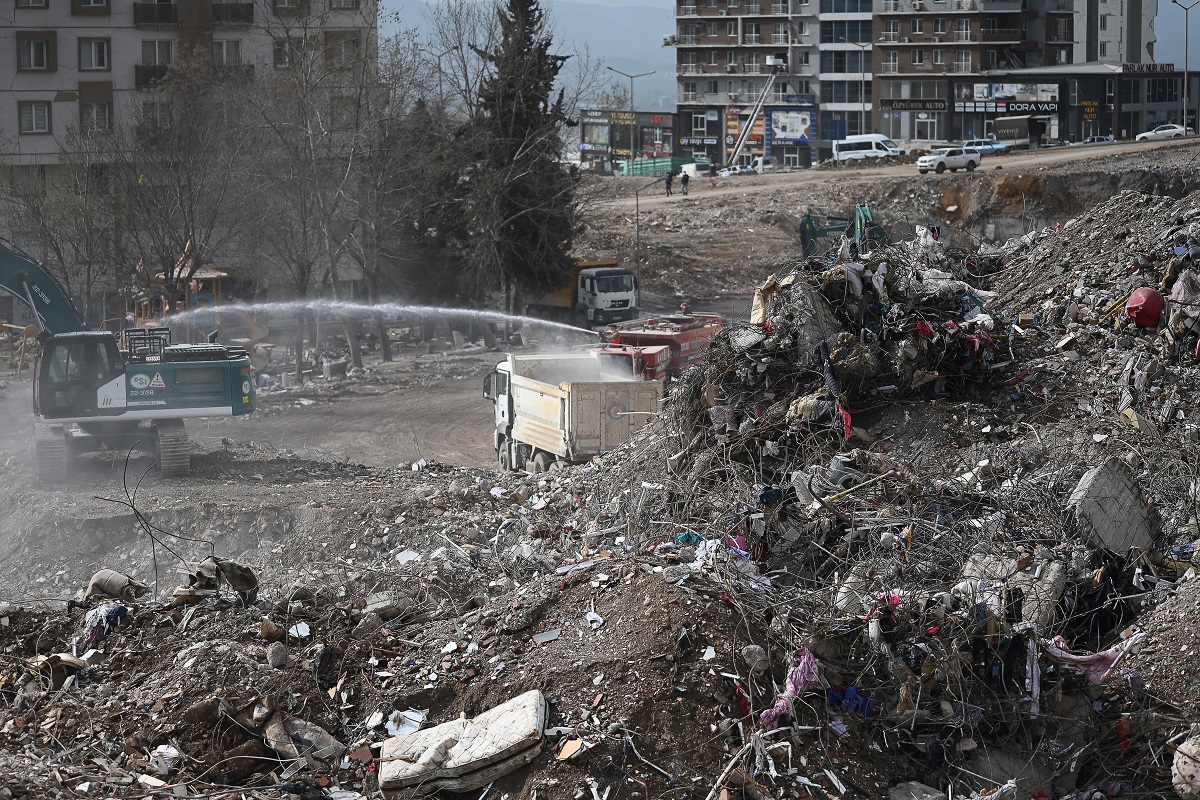 Los trabajadores limpian los escombros de los edificios derrumbados en Kahramanmaras, el 4 de marzo de 2023, un mes después de que un terremoto masivo azotara el sureste de Turquía. (Foto de Eylul YASAR / AFP)