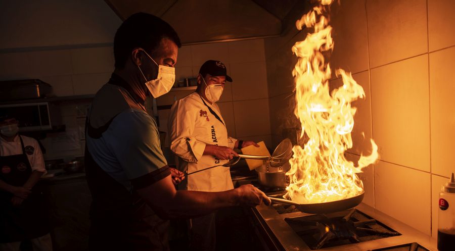 Julio Cesar Uribe al wok y su lado, el chef Carlos Acuna, ambos, socios del Jova Grill, el nuevo restaurante de carnes donde el mismo crack de la selección del 81 cocina. FOTO: Elías Alfageme.