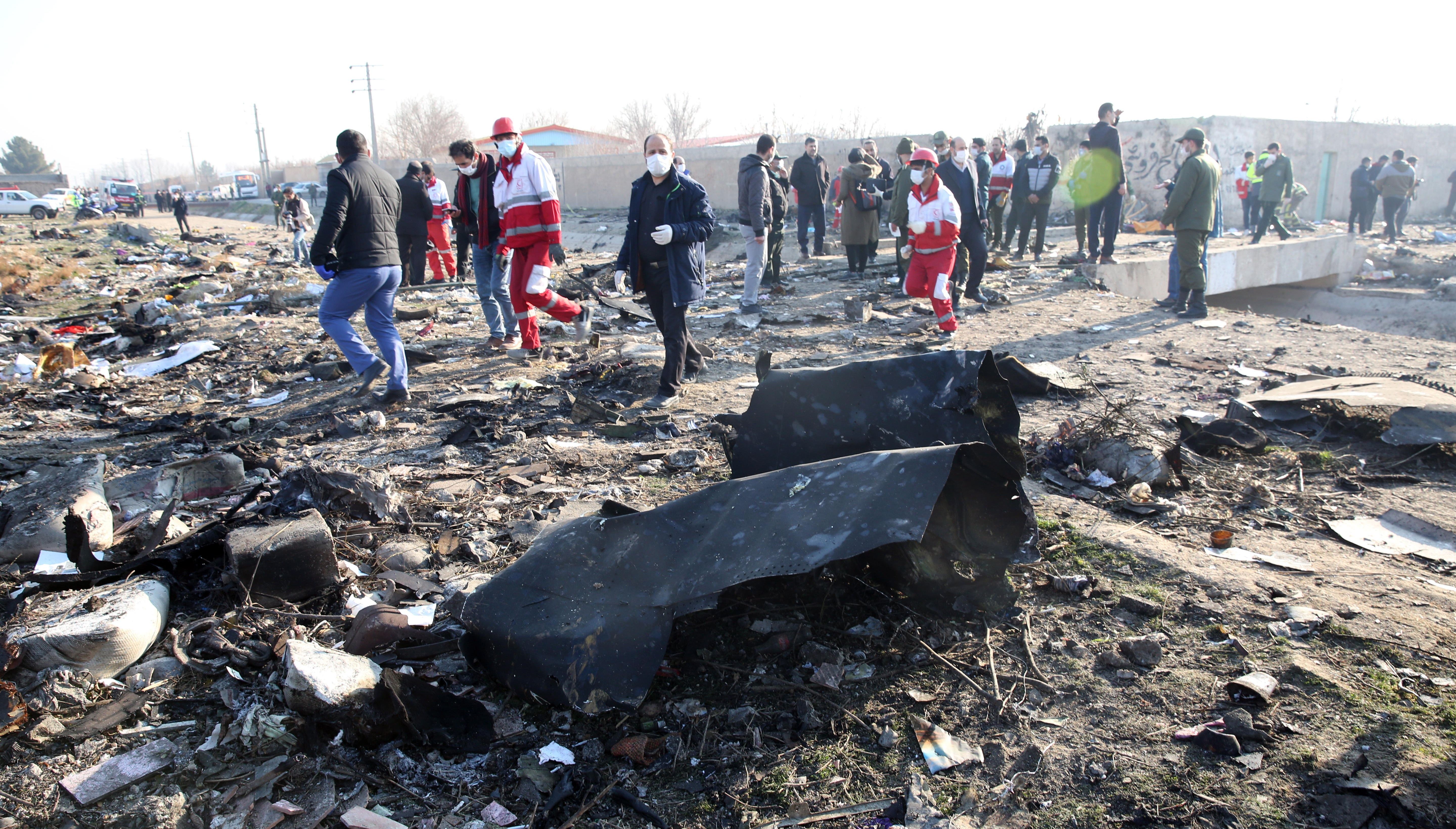 Shahriar (Iran (islamic Republic Of)), 08/01/2020.- Emergency services personnel walk amidst the wreckage after an Ukraine International Airlines Boeing 737-800 carrying 176 people crashed near Imam Khomeini Airport in Tehran, killing everyone on board; in Shahriar, Iran, 08 January 2020. (Ucrania, Teherán) EFE/EPA/ABEDIN TAHERKENAREH