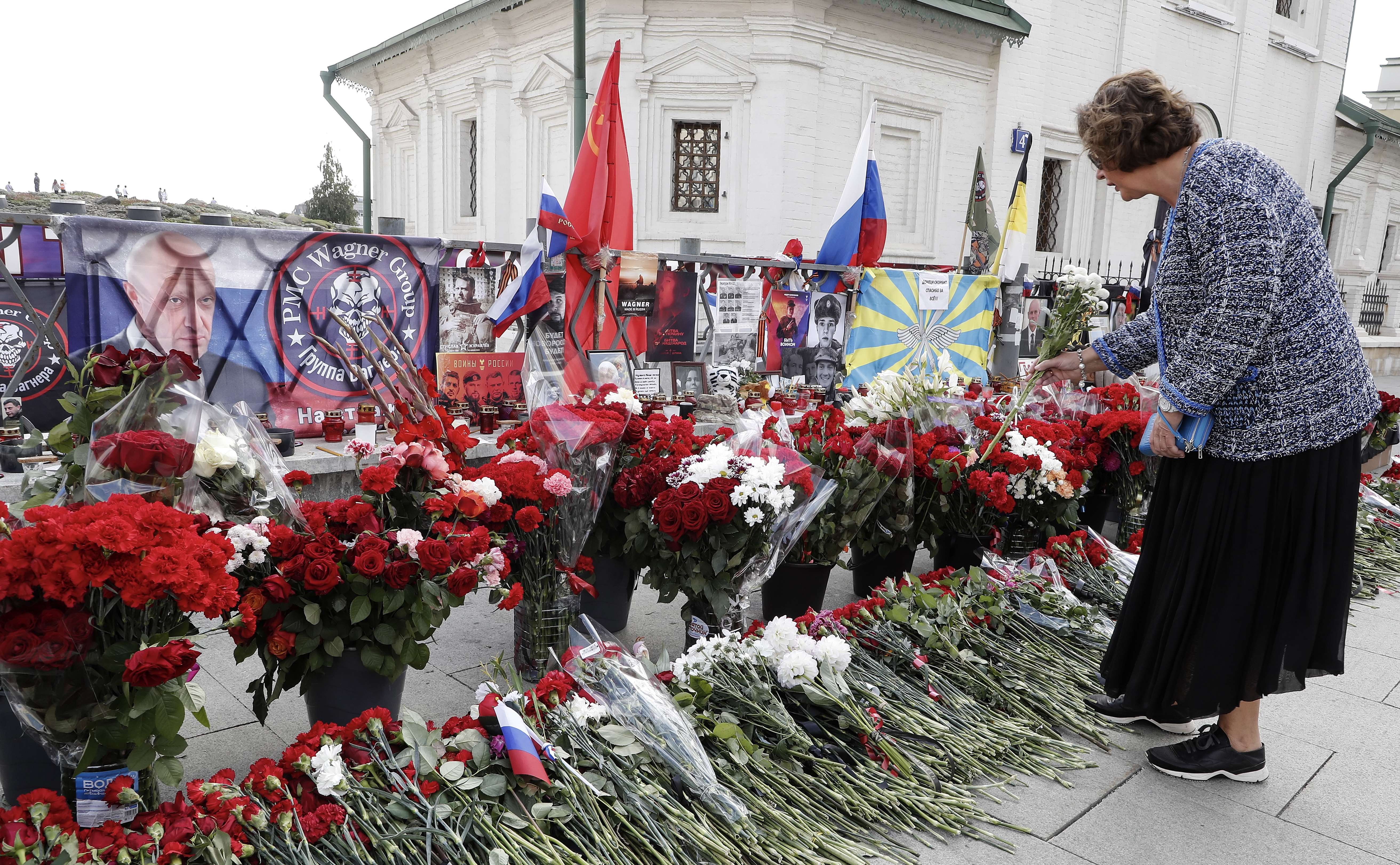 Moscow (Russian Federation), 28/08/2023.- A woman lays flowers at an informal memorial in tribute to Wagner Group chief Yevgeny Prigozhin in Moscow, Russia, 28 August 2023. An investigation was launched into the crash of an aircraft in the Tver region in Russia on 23 August 2023, the Russian Federal Air Transport Agency said in a statement. Among the passengers was Wagner chief Yevgeny Prigozhin, the agency reported. According to the results of genetic testing on the 10 bodies recovered at the crash site, Russian authorities on August 27 confirmed the death of Yevgeny Prigozhin. (Rusia, Ucrania, Moscú) EFE/EPA/MAXIM SHIPENKOV