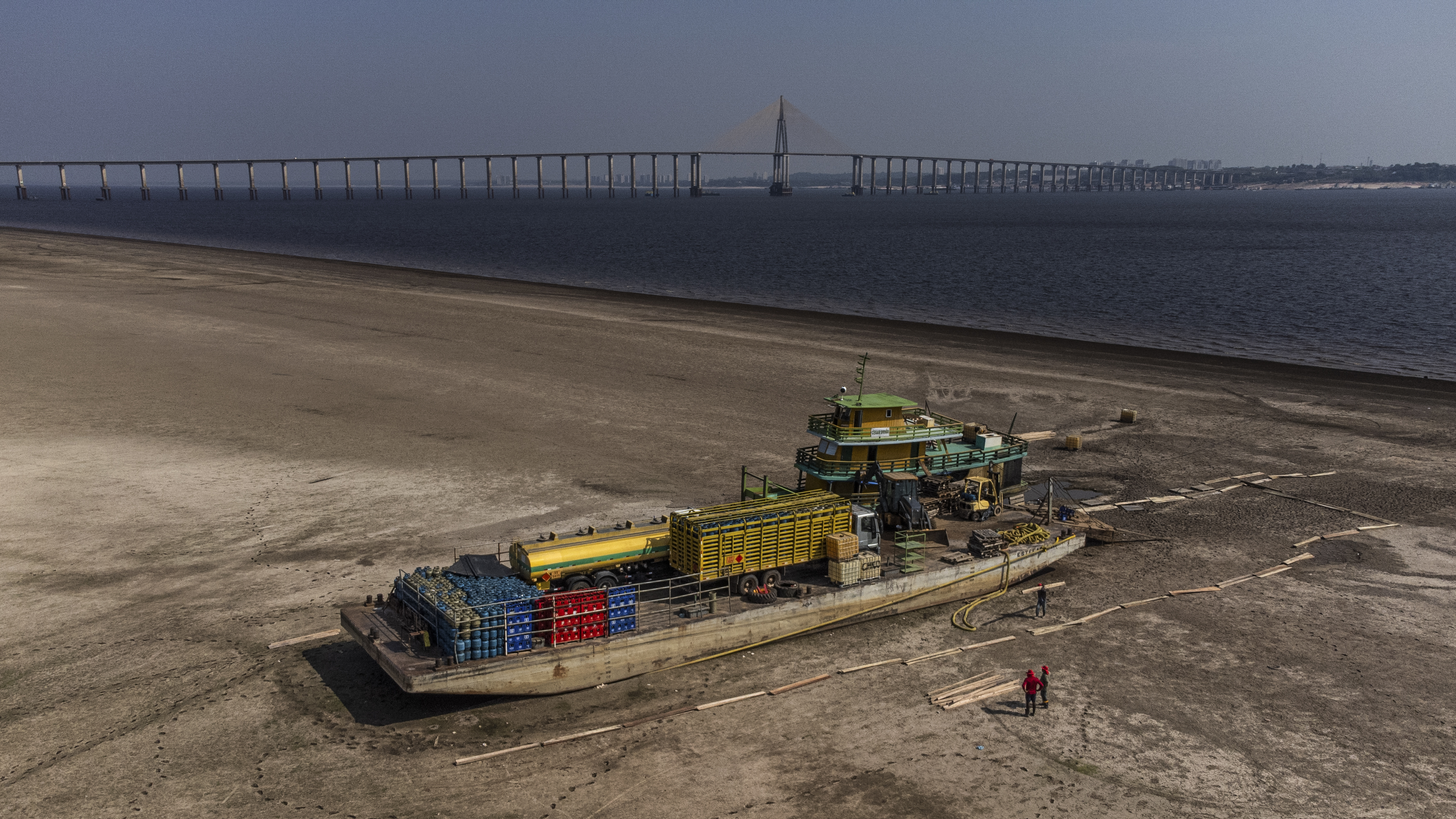 -FOTODELDÍA- AME4391. IRANDUBA (BRASIL), 03/10/2023.- Fotografía aérea que muestra un remolcador y un ferry que transportaba combustible, gasolina, bebidas y vehículos, encallados en un banco de arena formado por la fuerte sequía que azota los ríos de la cuenca del Amazonas, en el municipio de Iranduba, en la margen opuesta de Manaos, estado de Amazonas (Brasil). La actual sequía en la Amazonía, donde hay enormes áreas aisladas por dificultades en la navegabilidad de los ríos, puede ser histórica y extenderse hasta enero, según prevé el estatal Centro de Monitoreo de Alertas y Desastres Naturales (Cemaden). EFE/ Raphael Alves
