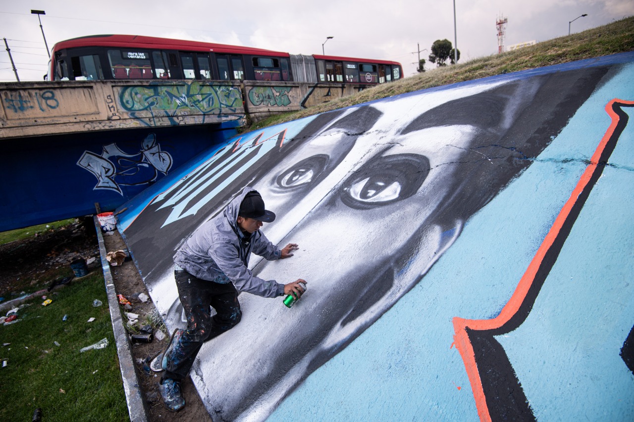 Un hombre pinta un grafiti sobre un muro