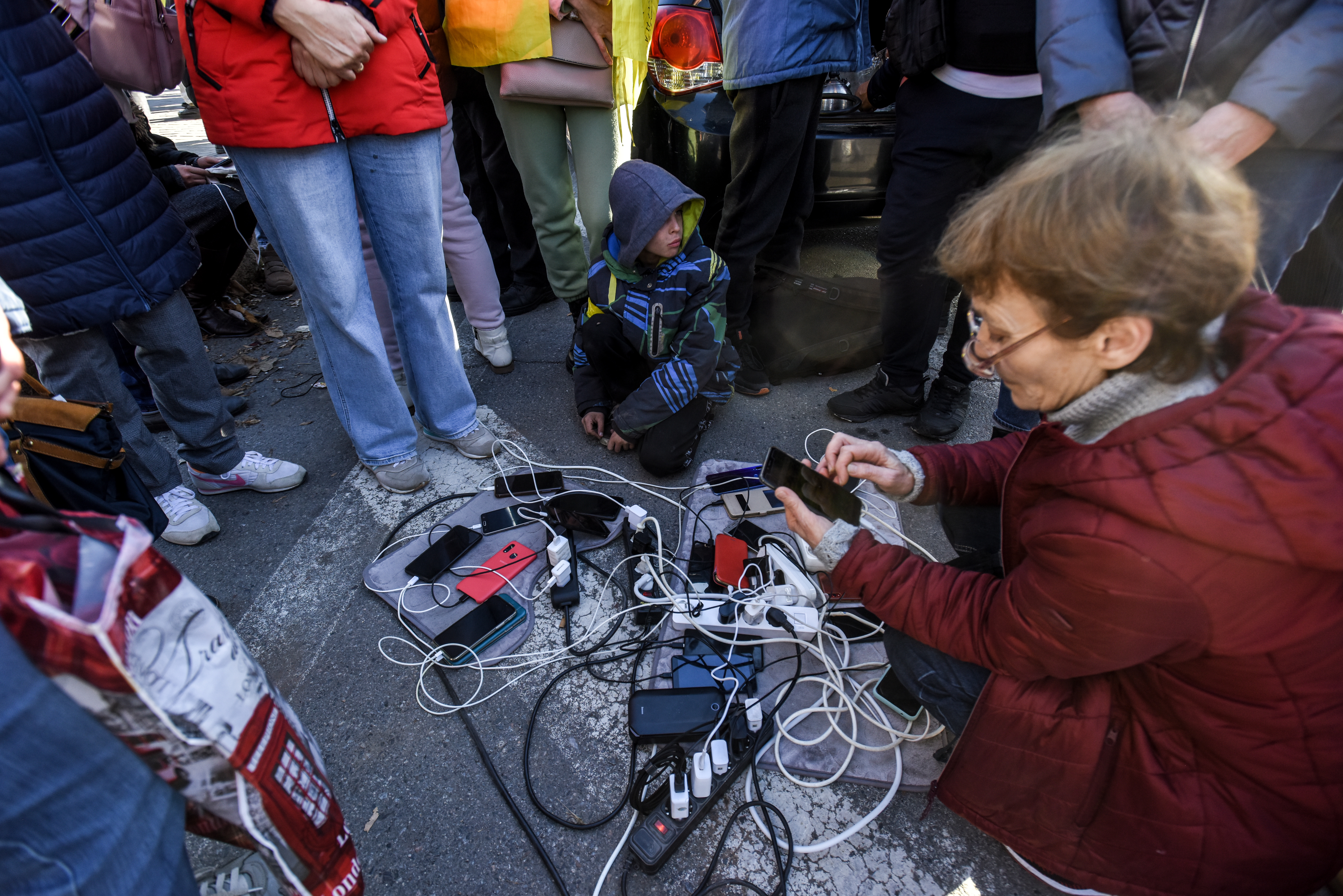 Kherson (Ukraine), 14/11/2022.- People charge their phones from the generator in the recaptured city of Kherson, Ukraine, 14 November 2022. Ukrainian troops entered Kherson on 11 November after Russian troops had withdrawn from the city. Kherson was captured in the early stage of the conflict, shortly after Russian troops had entered Ukraine in February 2022. (Rusia, Ucrania) EFE/EPA/OLEG PETRASYUK