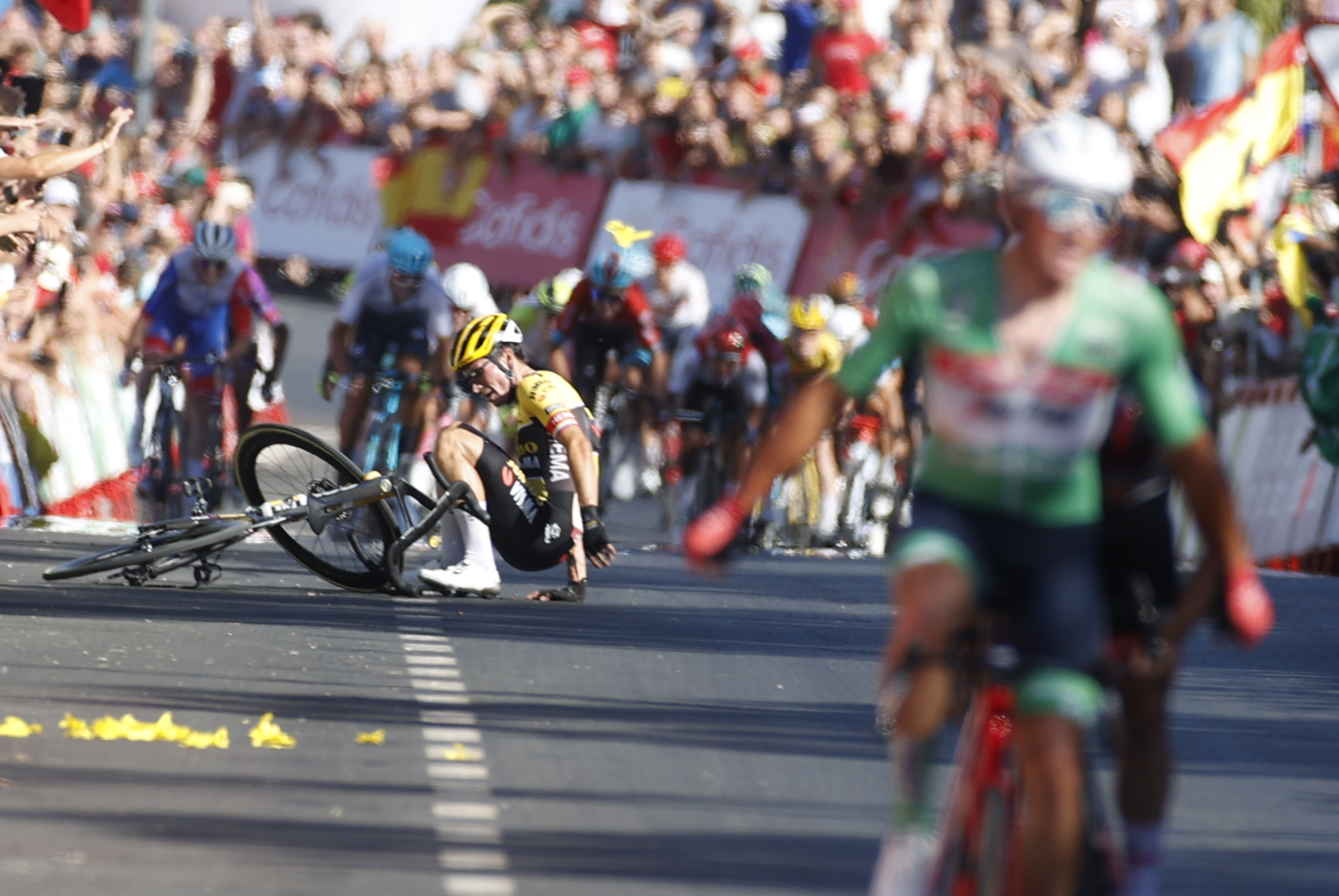 GRAF1586. LEBRIJA (SEVILLA), 06/09/2022.- El ciclista esloveno Primoz Roglic (i), del equipo Jumbo Visma, sufre una caída a pocos metros de la línea de meta al tiempo que el ciclista danés Mads Pedersen (d), del equipo Trek-Segafredo y líder de la regularidad, se proclama vencedor de la decimosexta etapa de la Vuelta a España, entre Sanlúcar de Barrameda y Tomares sobre 189,4 kilómetros, este martes. EFE/ Javier Lizón