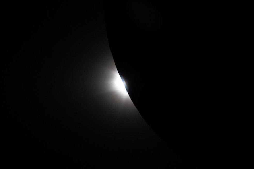 Esta imagen, tomada desde la nave espacial Orión, muestra al Sol comenzando a asomarse por detrás de la Luna mientras el eclipse sale de la totalidad.