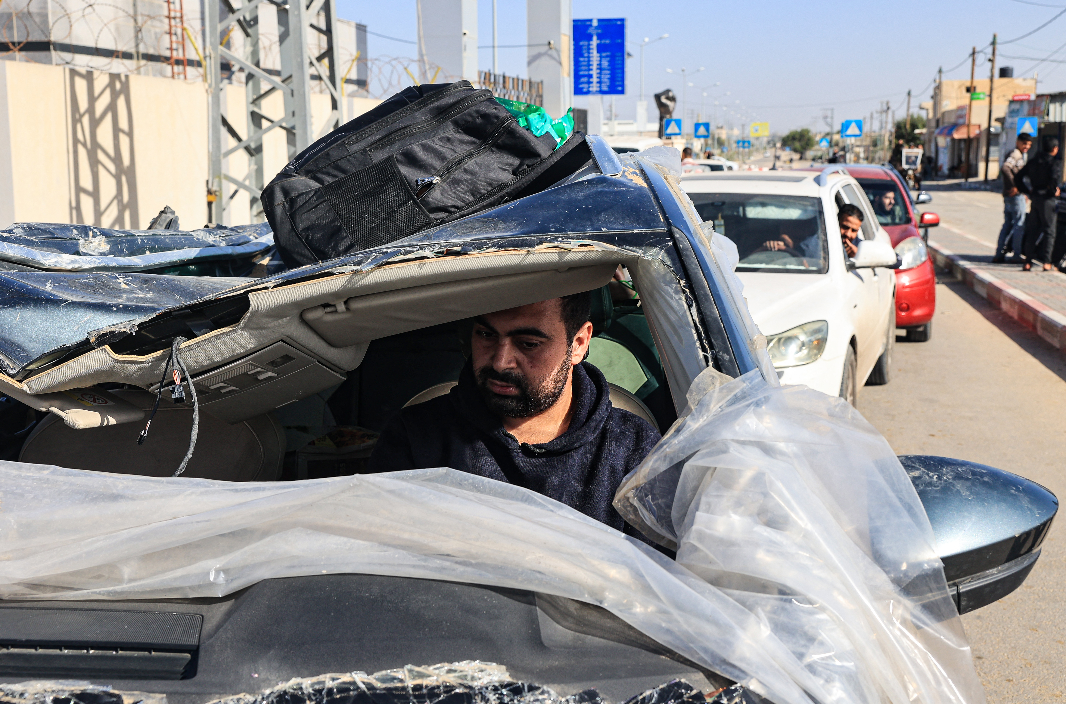 Un hombre que conduce un automóvil averiado recoge a familiares que regresan a la Franja de Gaza a través del cruce de Rafah con Egipto.