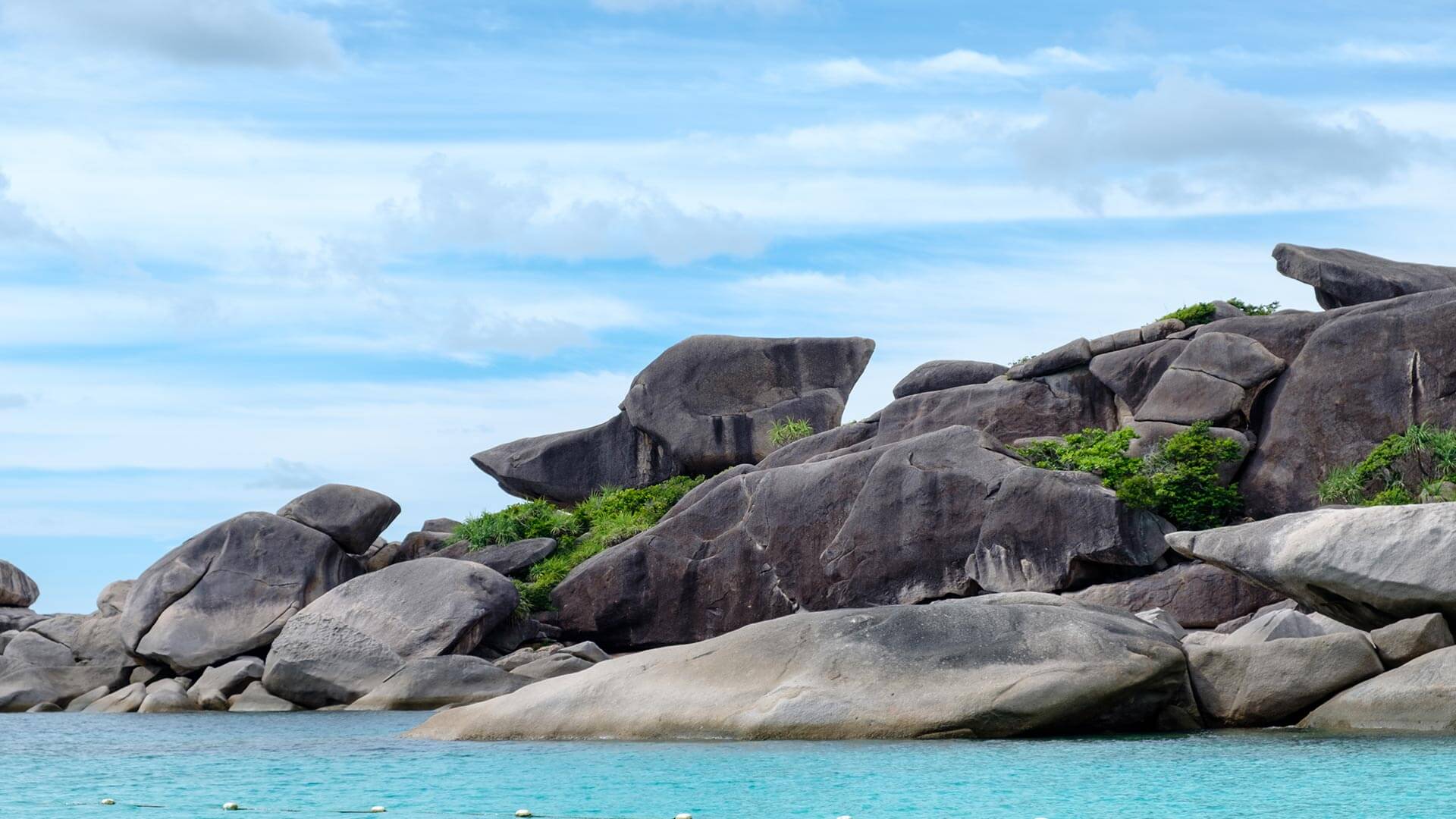 Donald Duck Bay es una de las playas más singulares de Tailandia, ubicada dentro del protegido Parque Nacional de las Islas Similan. Accesible solo por barco y durante la temporada abierta —generalmente de noviembre a mayo—, este destino conserva un entorno casi intacto gracias a sus restricciones de acceso. Sus aguas turquesas y tranquilas, la arena blanca y las enormes formaciones de granito, incluida la roca que le da su nombre, crean un paisaje inconfundible. La combinación de naturaleza preservada, poca afluencia y excelente visibilidad la convierte en un lugar ideal para nadar, hacer esnórquel y disfrutar de su costa.