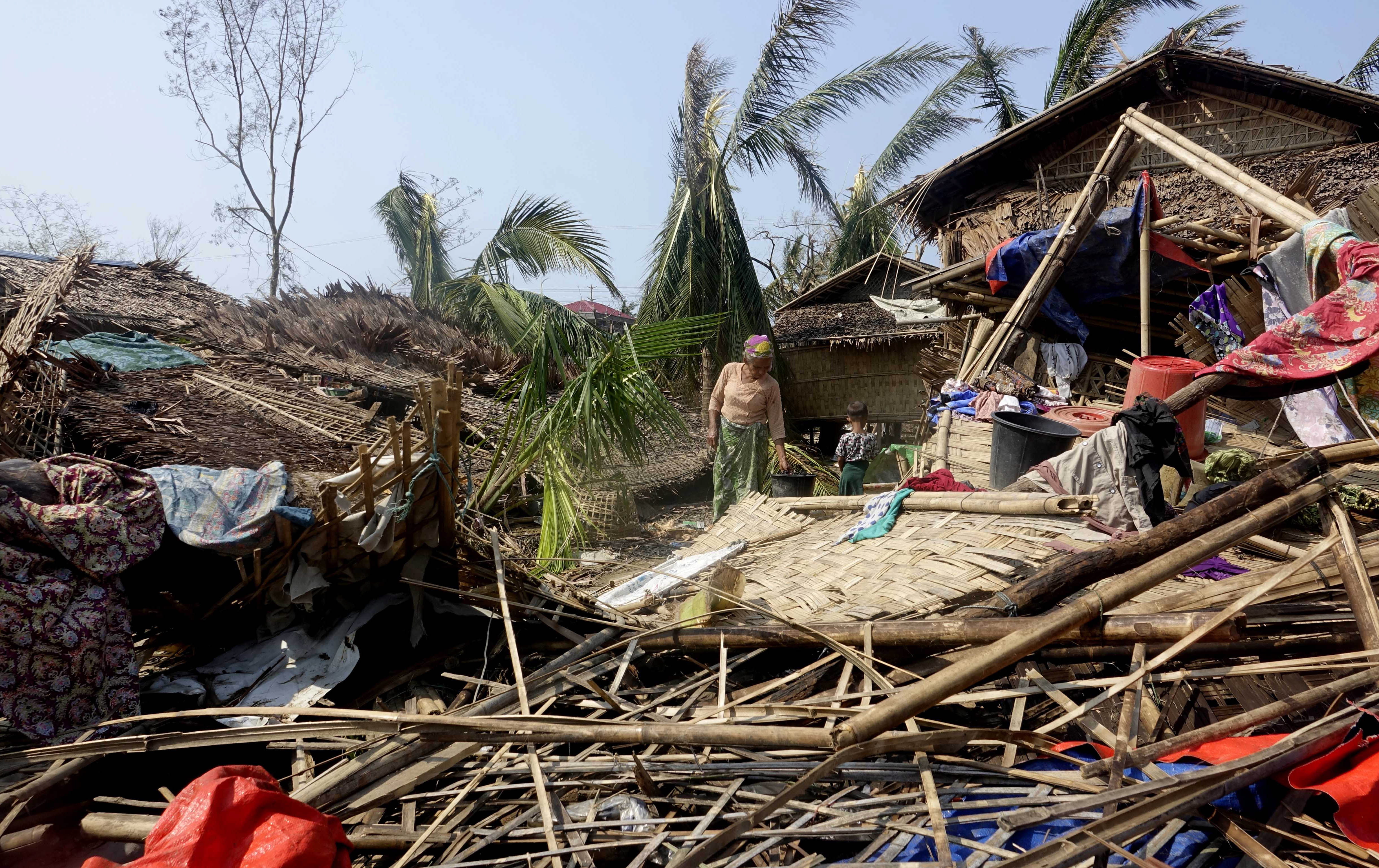 Sittwe (Myanmar), 16/05/2023.- A Rohingya woman stands near a damaged house at the Thae Chaung Muslim internally displaced people (IDPs) camp near Sittwe, Rakhine State, Myanmar, 17 May 2023. On 14 May tropical cyclone 'Mocha' hit the coastal regions of Myanmar and Bangladesh with maximum sustained winds of 250 kph, wreaking havoc on thousands of vulnerable communities. According to the Global Disaster Alert and Coordination System (GDACS), around three million people in Myanmar and Bangladesh were affected by the strong winds. The world's largest refugee camp in Cox's Bazar in southern Bangladesh and Rakhine State in western Myanmar were on the cyclone's route. The UN humanitarian aid office OCHA warned that torrential rains and heavy floods in cyclone-hit areas have also increased the risk of landslides ahead of the monsoon season. (Inundaciones, Birmania, Estados Unidos) EFE/EPA/STRINGER