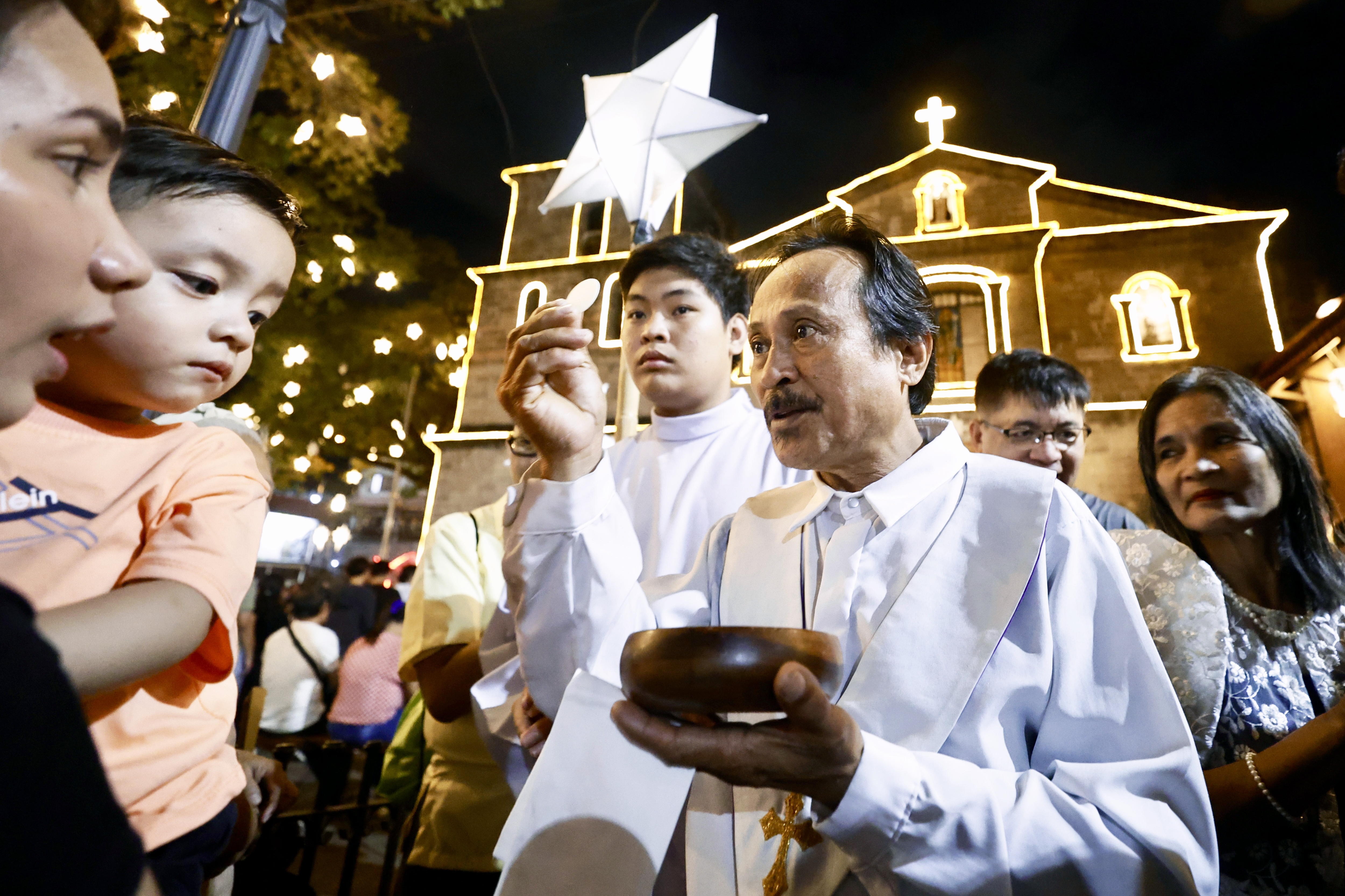 Las Pinas (Philippines), 15/12/2024.- A layperson offers communion to Catholic faithful during a Misa de Gallo (dawn mass) in Las Pinas, Metro Manila, Philippines, 16 December 2024. Catholics traditionally attend nine straight dawn masses before Christmas Day on 25 December as an expression of religious faith. (Filipinas) EFE/EPA/FRANCIS R. MALASIG