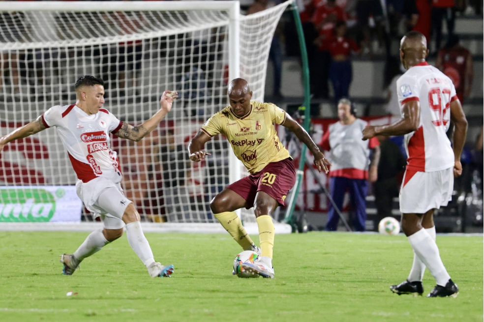 Junior Hernández, del Tolima, conduce la pelota ante la marca de Harold Rivera (izq.) y Yerson Candelo.