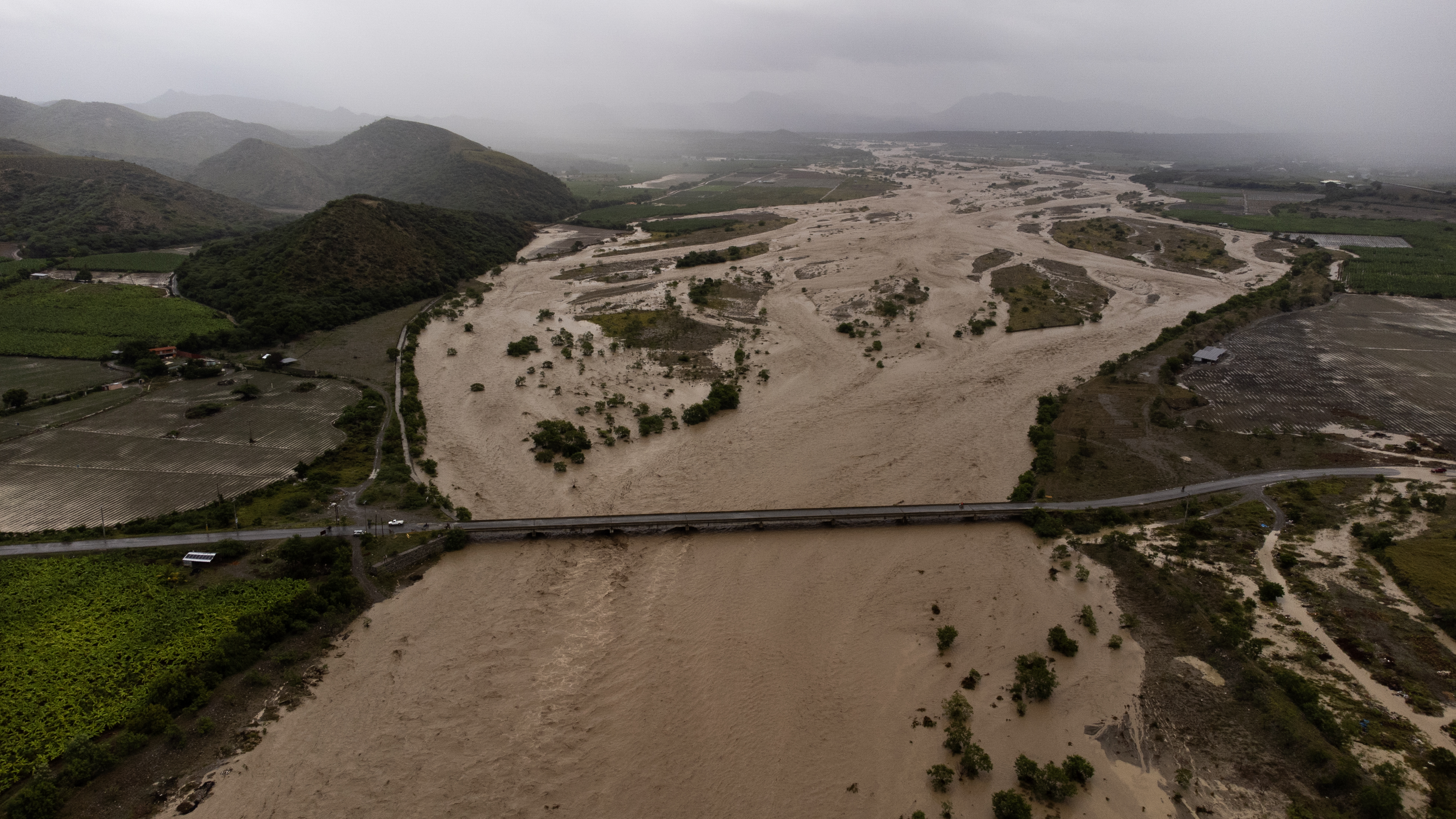 -FOTODELDÍA- PALMAR DE OCOA (REPÚBLICA DOMINICANA), 04/10/2023.- Fotografía aérea que muestra el Río Ocoa completamente desbordado y con un intenso caudal producto de la fuertes lluvias, hoy en Palmar de Ocoa (República Dominicana). Una persona está desaparecida, al menos 1.522 fueron desplazadas de sus hogares y un puente colapsó debido a las intensas lluvias en la República Dominicana, que han llevado a las autoridades a decretar la alerta en 30 de las 32 provincias del país, 11 en nivel rojo. EFE/Orlando Barría