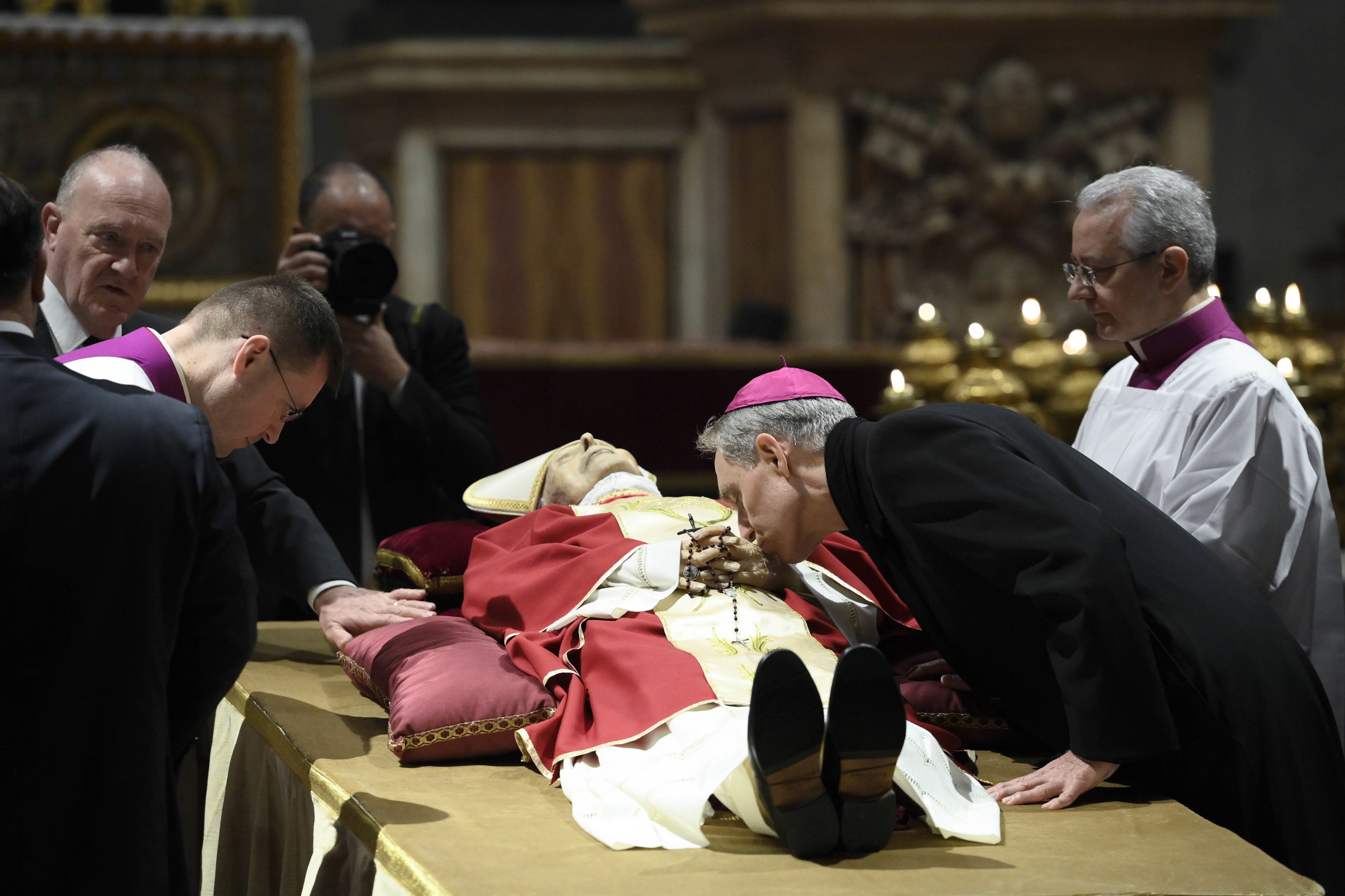 Vatican City (Vatican City State (holy See)), 02/01/2023.- A handout photo made available by Vatican Media shows Archbishop Georg Gaenswein kissing the hand of late Pope Emeritus Benedict XVI (Joseph Ratzinger) as his body lies in state in Saint Peter's Basilica for public viewing, Vatican City, 02 January 2023. Former Pope Benedict XVI died on 31 December at his Vatican residence, aged 95. For three days, starting from 02 January, the body will lay in state in St Peter's Basilica until the funeral on 05 January. (Papa) EFE/EPA/VATICAN MEDIA HANDOUT EDITORIAL USE ONLY/NO SALES