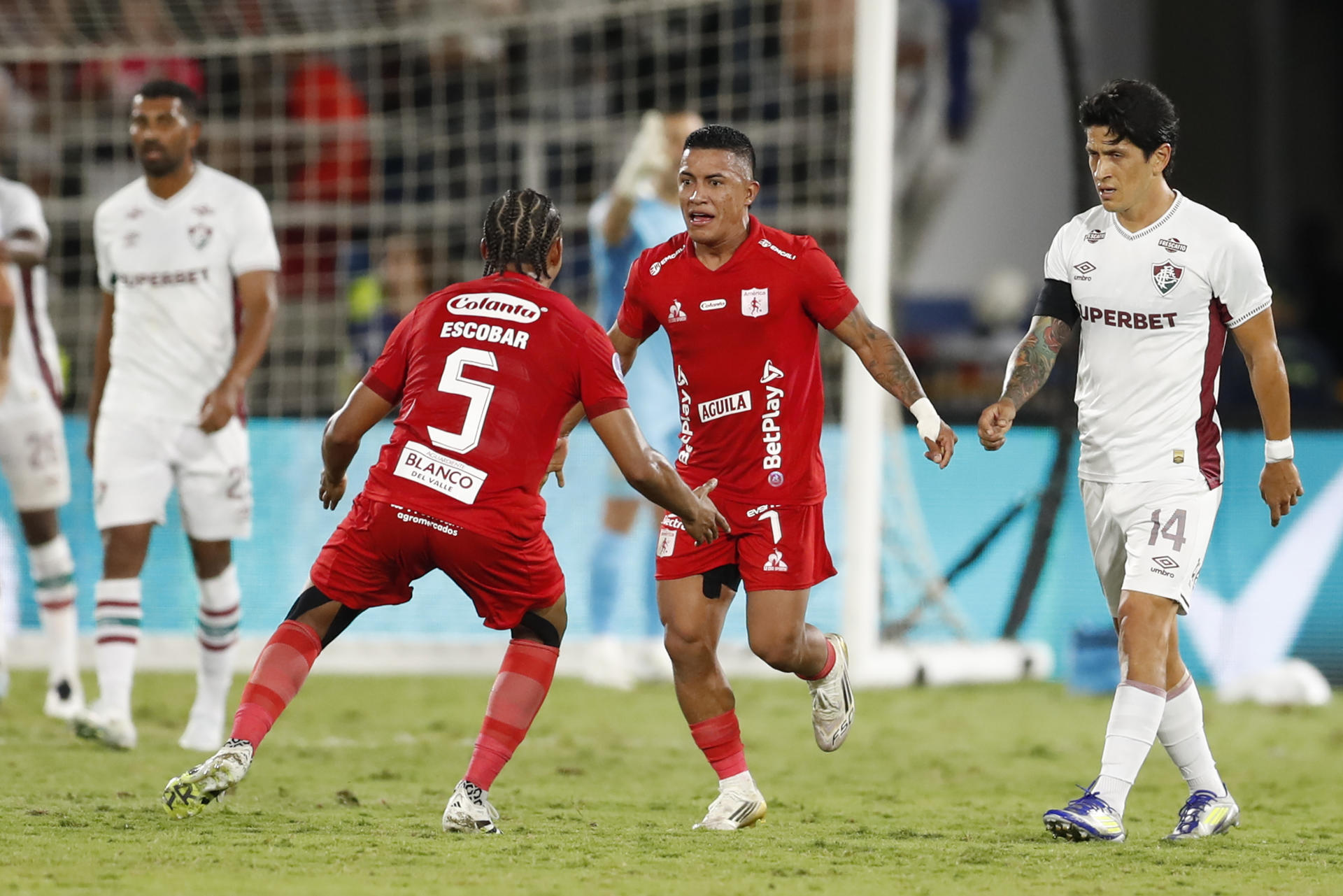 AMDEP185. CALI (COLOMBIA), 12/08/2025.- Cristian Barrios (d) y Josen Escobar de América de Cali celebran un gol este martes, durante un partido de octavos de final de la Copa Sudamericana entre América de Cali y Fluminense en el estadio Pascual Guerrero de Cali (Colombia). EFE/ Ernesto Guzmán JR