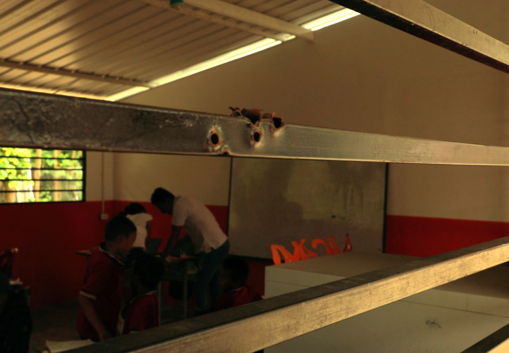 Impactos de bala en la escuela de Mesitas.David Leonardo Carranza MuñozEl Consejo Noruego para Refugiados donó los salones de primaria que están hechos con concreto. Sin embargo, en el cemento se ven los impactos de los proyectiles y los marcos de las ventanas están rasgados por las balas. En ese lugar estudian 157 niños y niñas.
