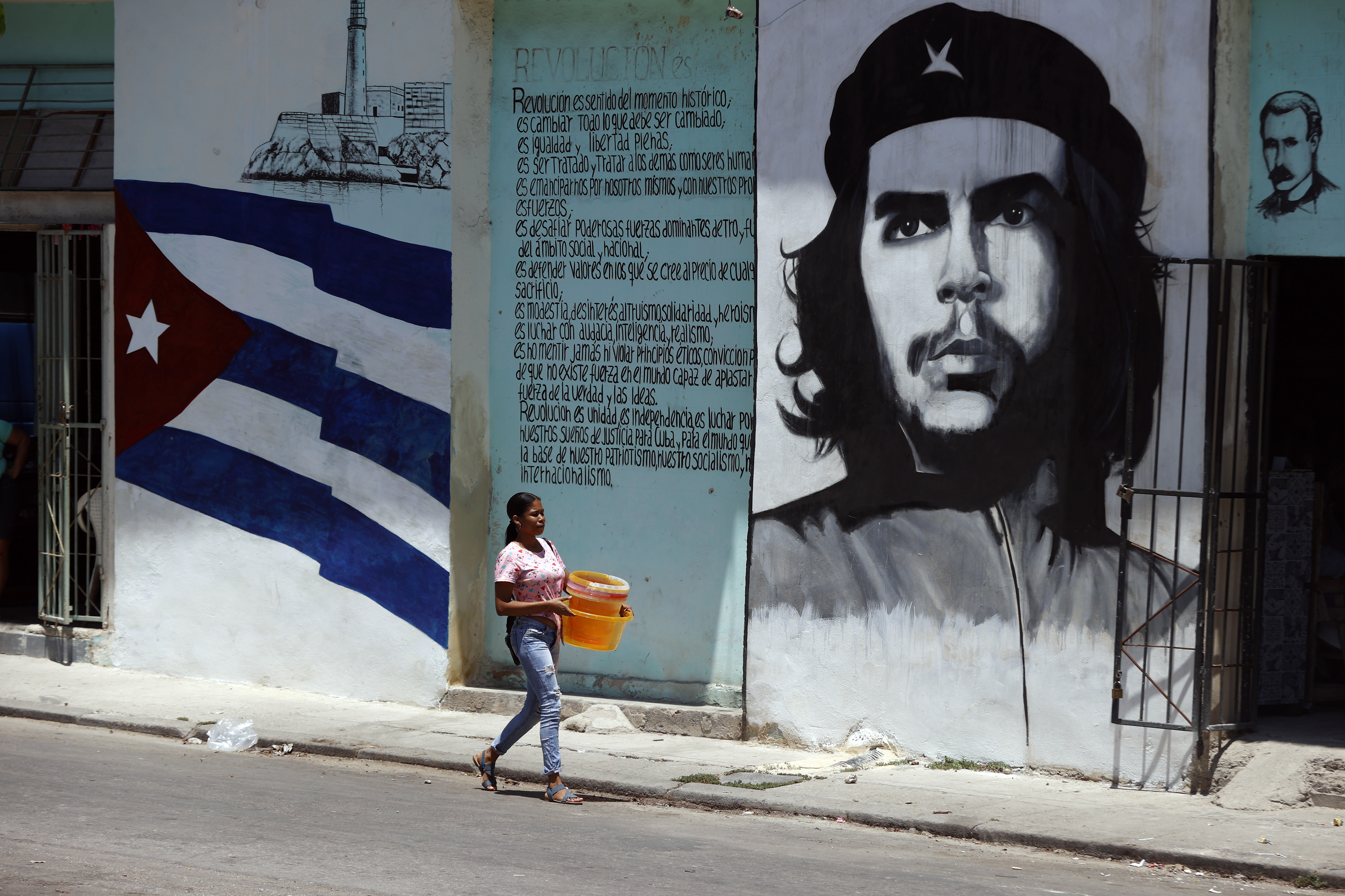 AME655. LA HABANA (CUBA), 26/04/2024.- Una mujer camina frente a un mural con la imagen de Ernesto Ché Guevara este viernes en una calle de La Habana (Cuba). EFE/ Ernesto Mastrascusa