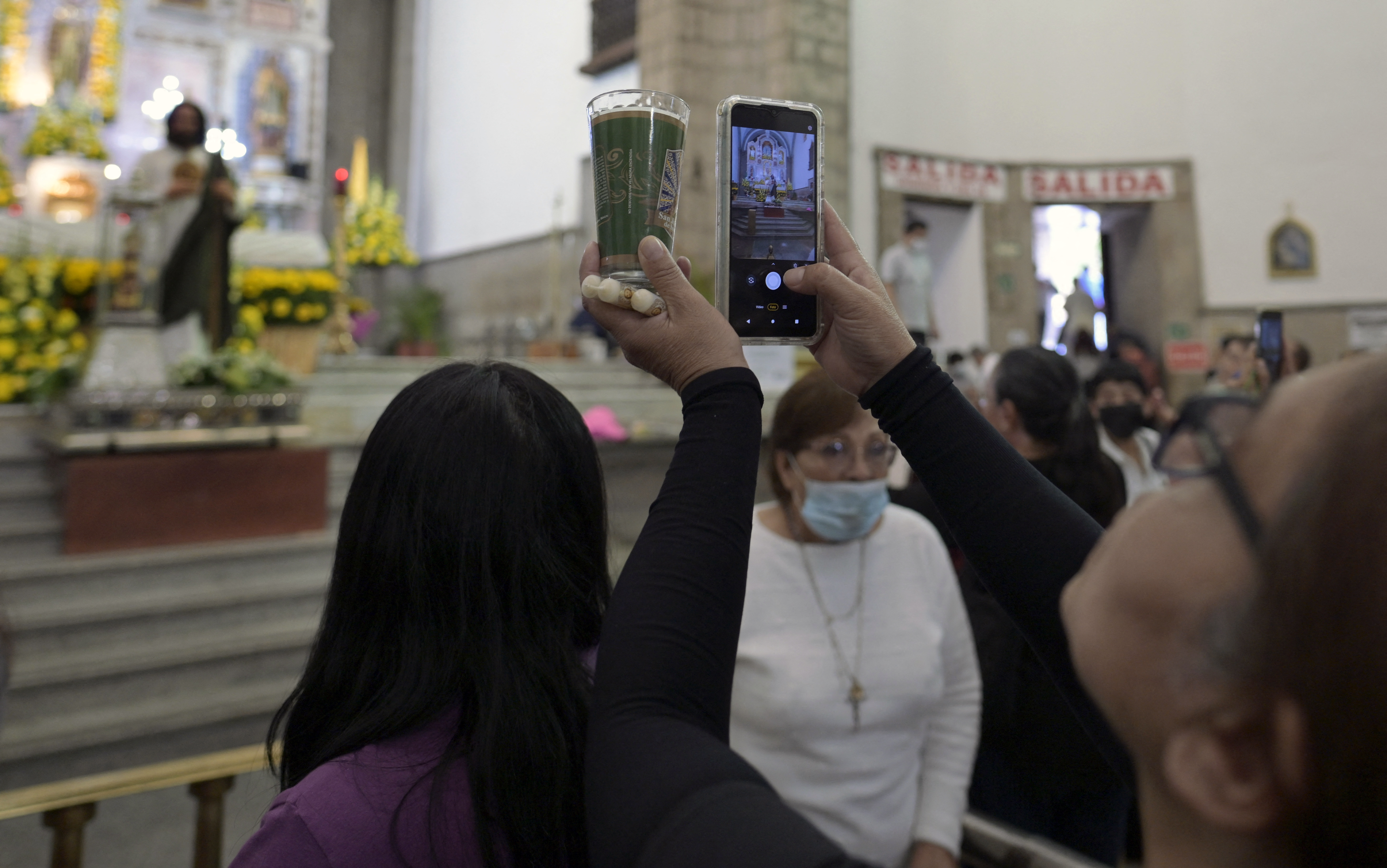 A group of faithful take pictures of the relic of Saint Jude Thaddeus at the Temple of San Hipólito in Mexico City on August 1, 2024.