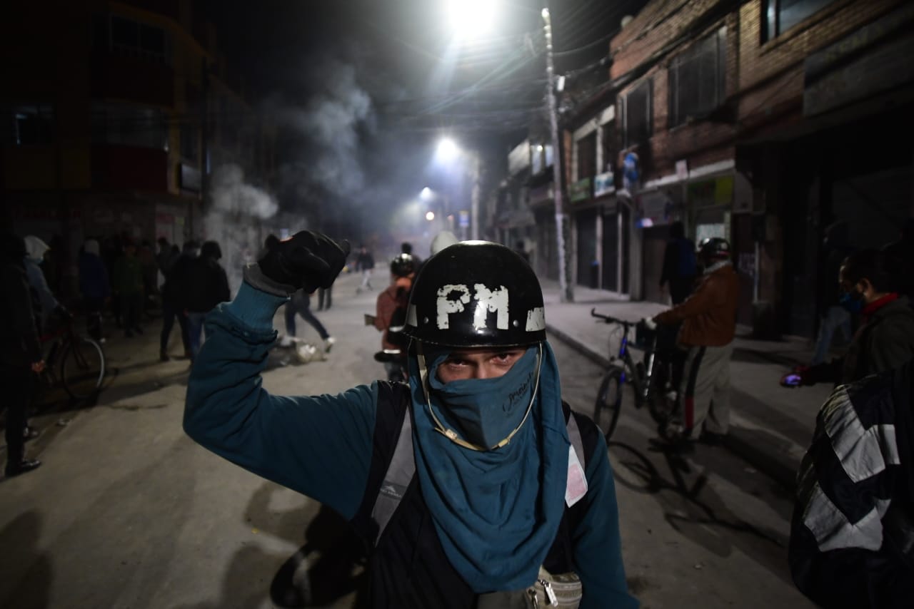 Un hombre encapuchado co un casco de la Policía