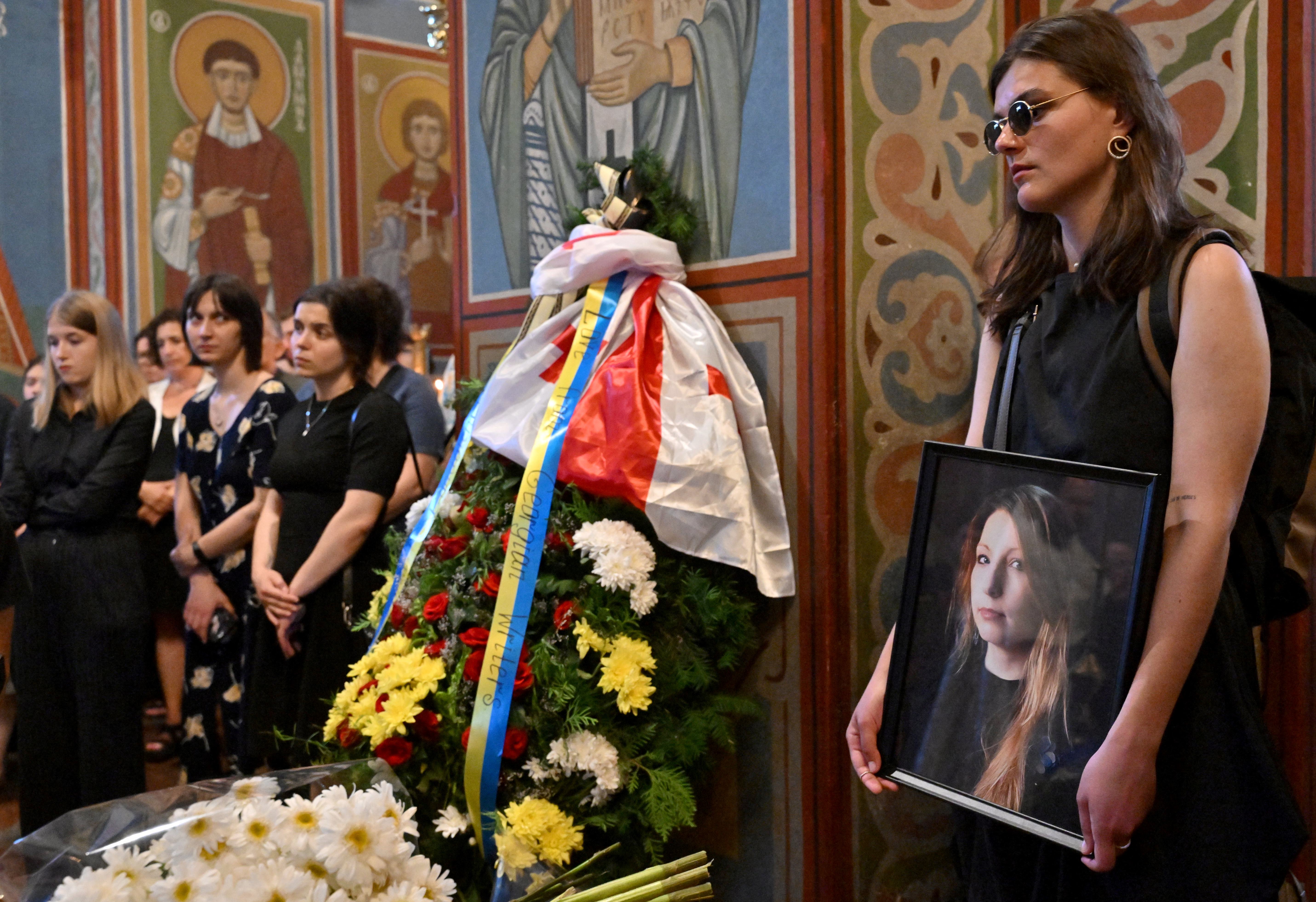 Unas 200 personas, entre ellas sus familiares, su hijo de 10 años y numerosos escritores y periodistas se acercaron para darle el último adiós al ataúd recubierto por una bandera con los colores amarillo y azul de Ucrania y rodeado de flores.