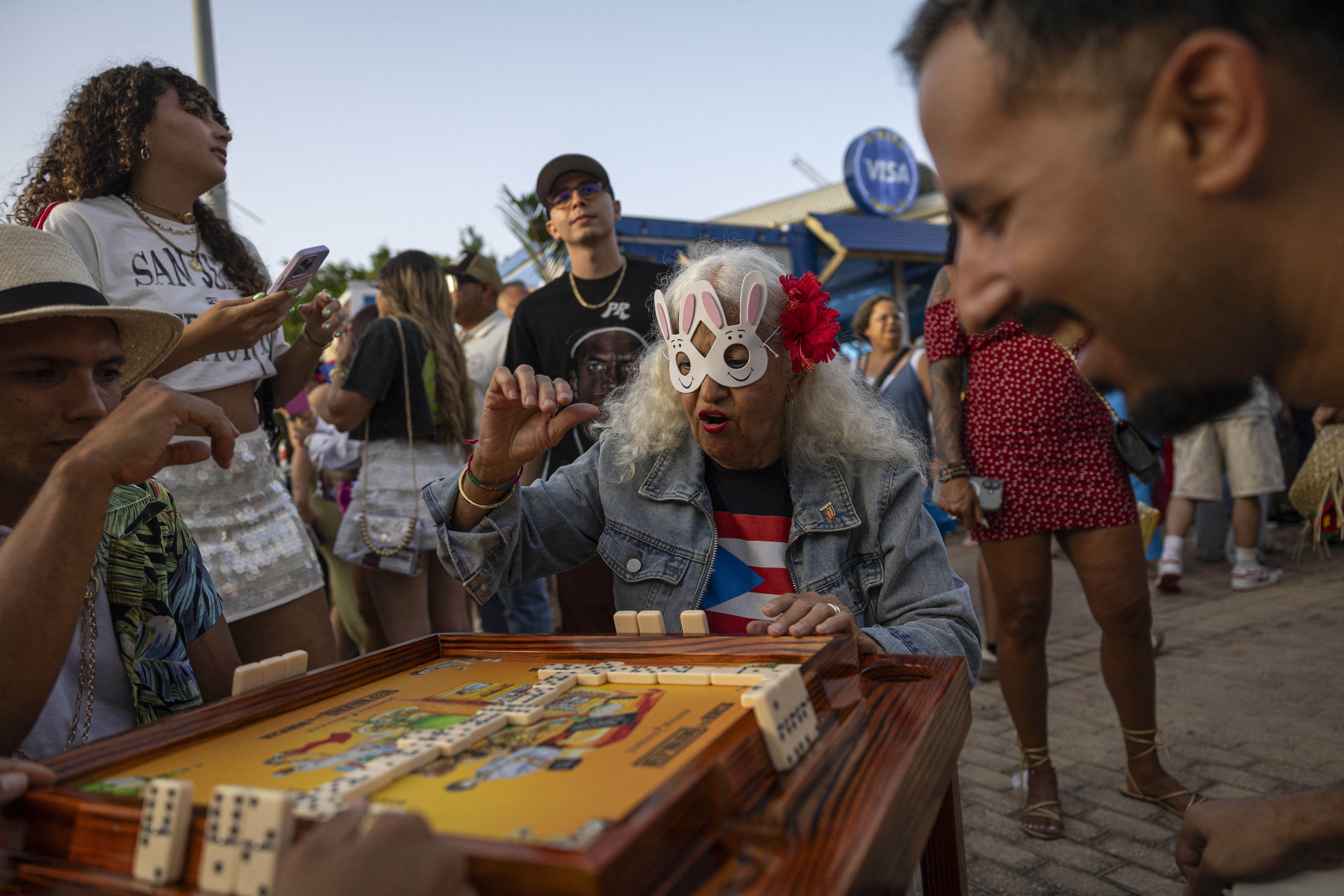 People play dominoes outside the Coliseo de Puerto Rico before the first show of Puerto Rican singer Bad Bunny's 30-date concert residency in San Juan, Puerto Rico, on July 11, 2025.