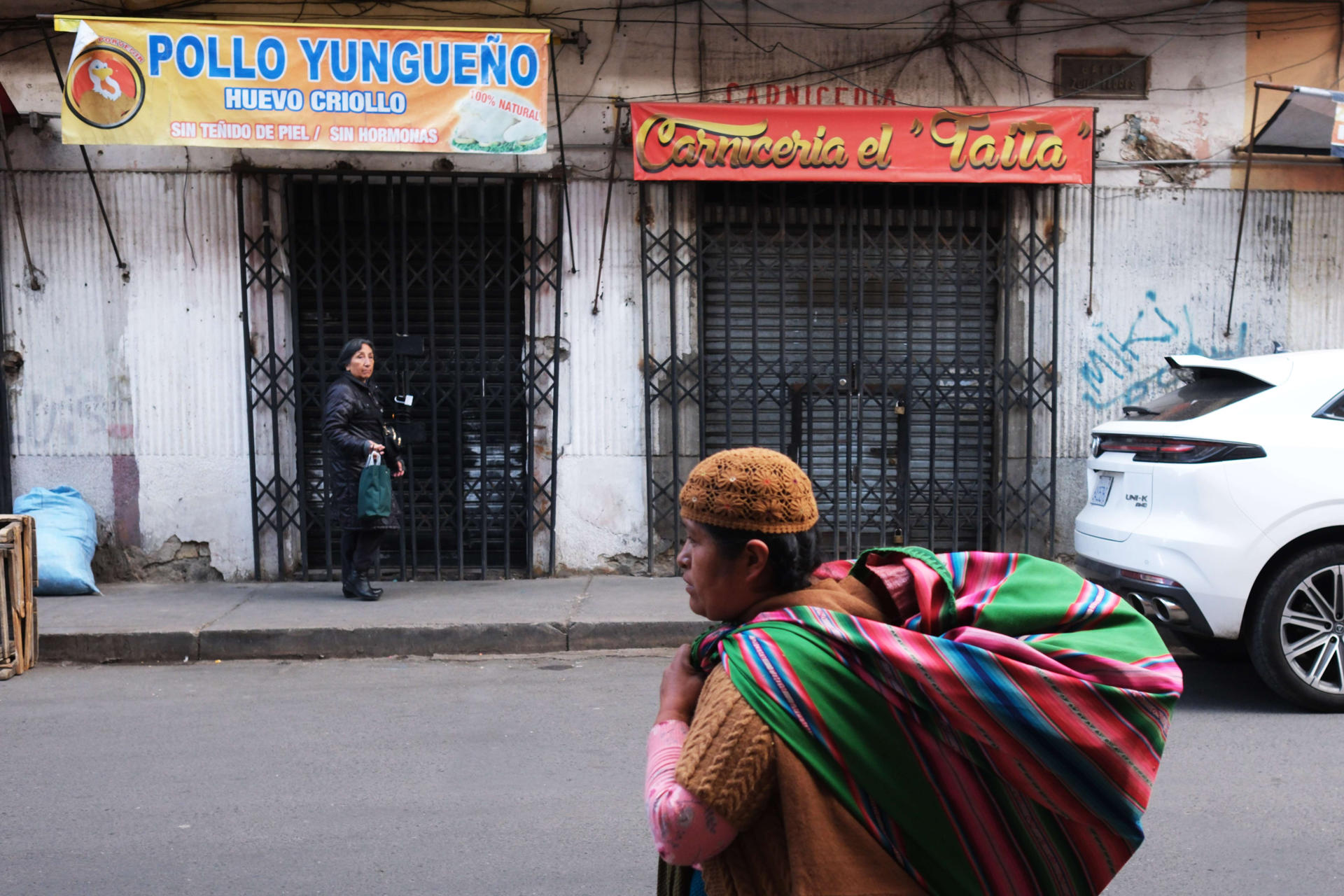 AME8138. LA PAZ (BOLIVIA), 03/06/2026.- Una mujer aimara camina frente a negocios cerrados este miércoles, en La Paz (Bolivia). EFE/Luis Gandarillas