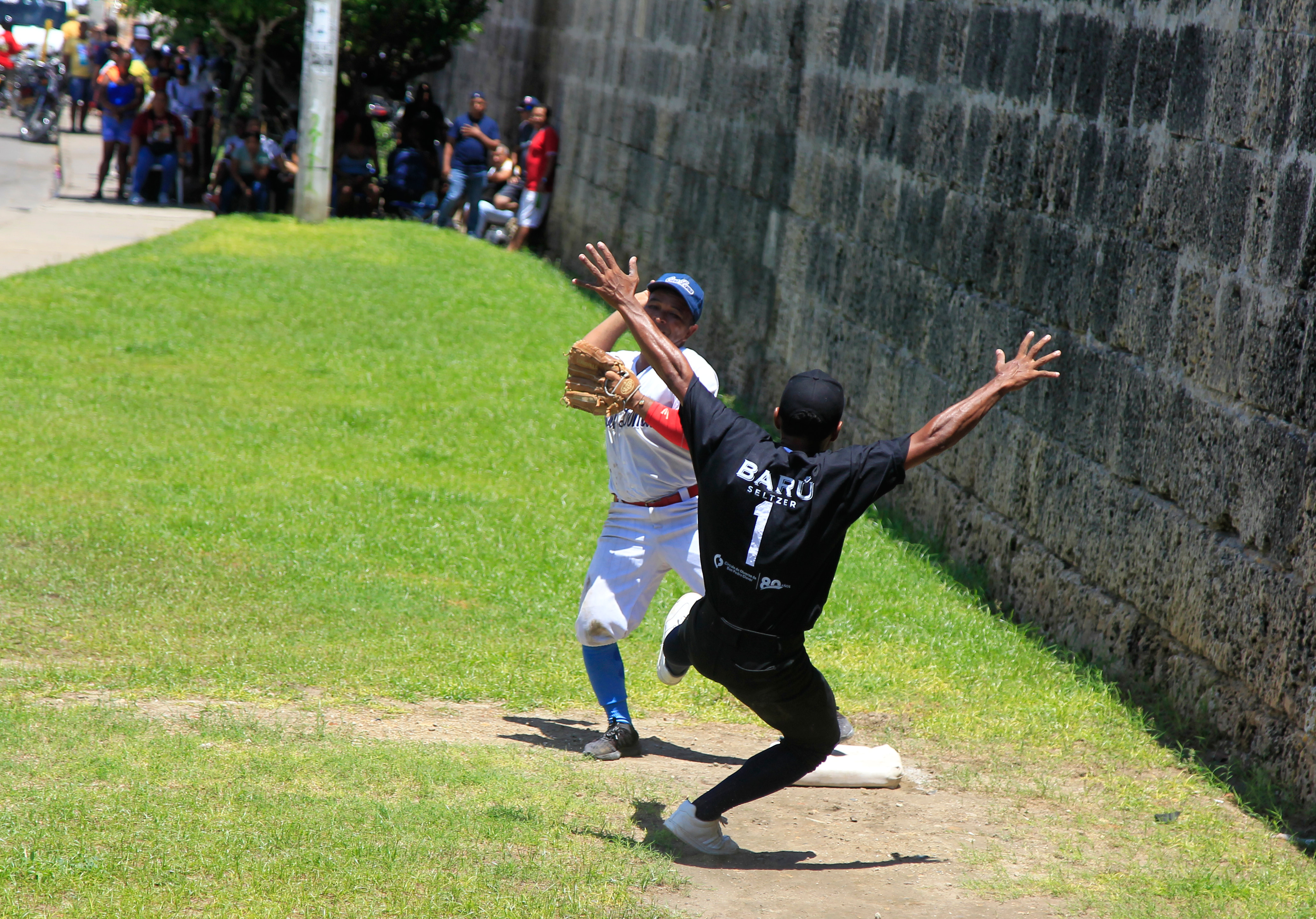 AME1762. CARTAGENA (COLOMBIA), 02/10/2022.- Habitantes del histórico barrio de Getsemaní juegan la final del campeonato de Bola de Trapo, un tradicional juego similar al beisbol que se juega con una bola elaborada con trapos e hilo forrados con un cuero semejando la original pelota caliente, en Cartagena (Colombia). Esta es una tradición que los getsemanicenses tratan de mantener viva a pesar de no contar con ninguna clase de apoyo por parte de las autoridades municipales de la ciudad, y es también una forma de resistencia frente a la fuerte gentrificación que sufre este sector de la ciudad invadido por el turismo. EFE/ Ricardo Maldonado Rozo