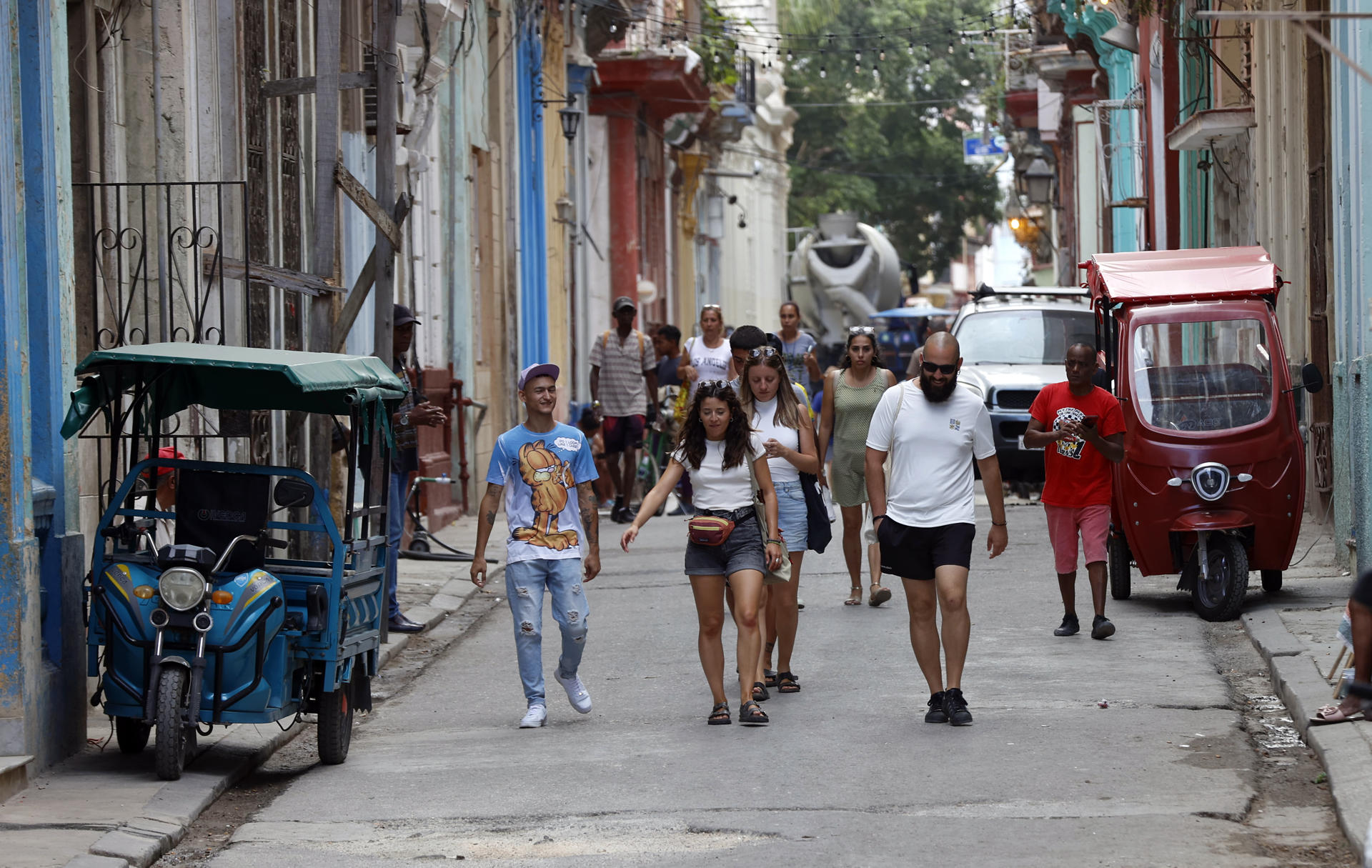 AME2881. LA HABANA (CUBA), 27/04/2025.- Turistas pasean este viernes, en una calle de La Habana (Cuba). El fin de la temporada alta en Cuba ha puesto de nuevo en evidencia que el turismo sigue sin levantar cabeza en una isla que durante décadas tuvo a este sector como motor de la economía y fuente fundamental de divisas. EFE/ Ernesto Mastrascusa