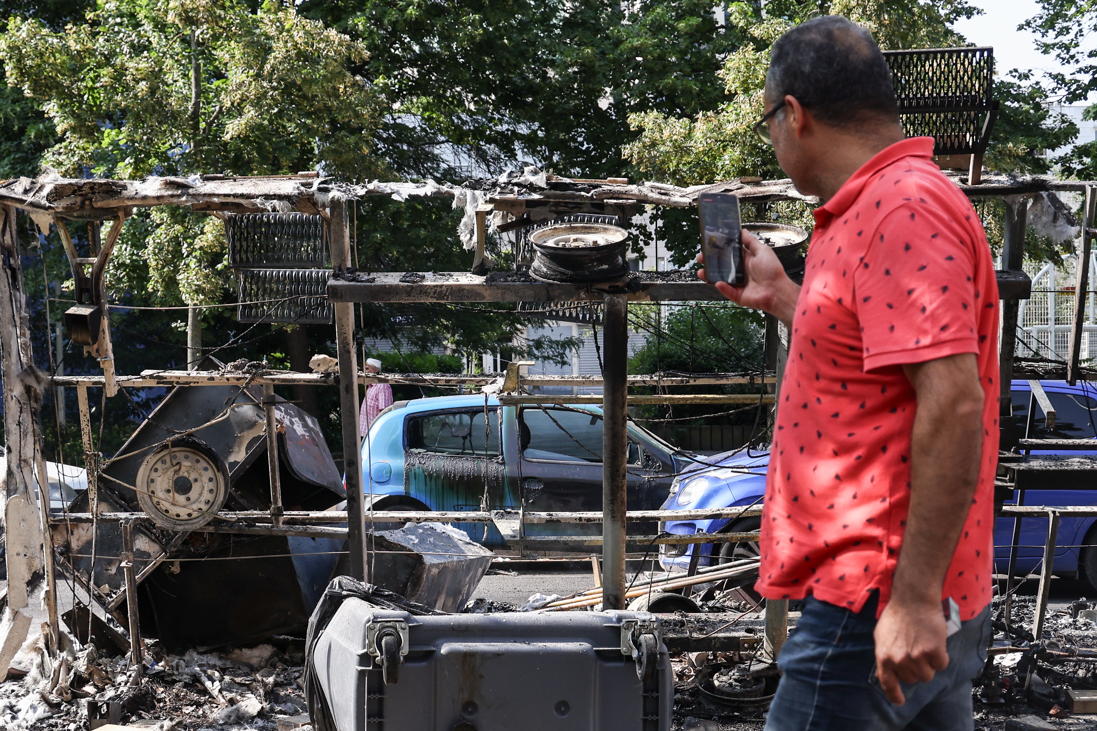 Nanterre (France), 28/06/2023.- A man takes photos of burnt out cars and debris on avenue Pablo Picasso following a night of civil unrest, in Nanterre, near Paris, France, 28 June 2023. The violence broke out after police fatally shot a 17-year-old during a traffic stop in Nanterre. According to the French interior minister, 31 people were arrested with 2,000 officers being deployed to prevent further violence. (Disturbios, Francia) EFE/EPA/Mohammed Badra