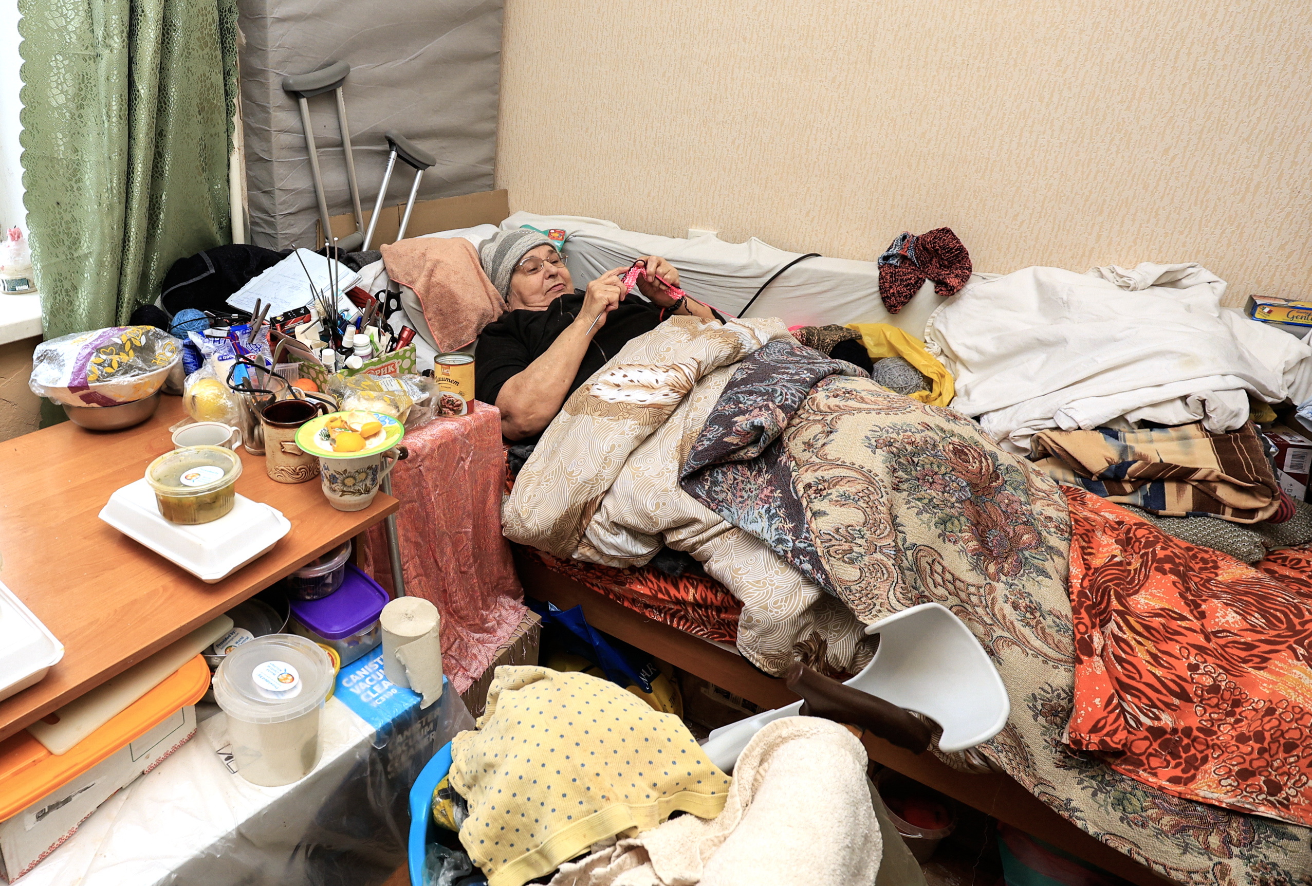 Kharkiv (Ukraine), 27/11/2024.- Zinaida, 67, an elderly disabled woman who was evacuated from Kupiansk-Vuzlovyi, knits socks for Ukrainian soldiers at a shelter in Kharkiv, Ukraine, 27 November 2024, amid the Russian invasion. According to the head of the Kharkiv Military Administration, almost 22,000 people were evacuated from dangerous areas of the Kharkiv region between May and November 2024. Russian troops entered Ukrainian territory on 24 February 2022, starting a conflict that has provoked destruction and a humanitarian crisis. (Rusia, Ucrania) EFE/EPA/SERGEY KOZLOV